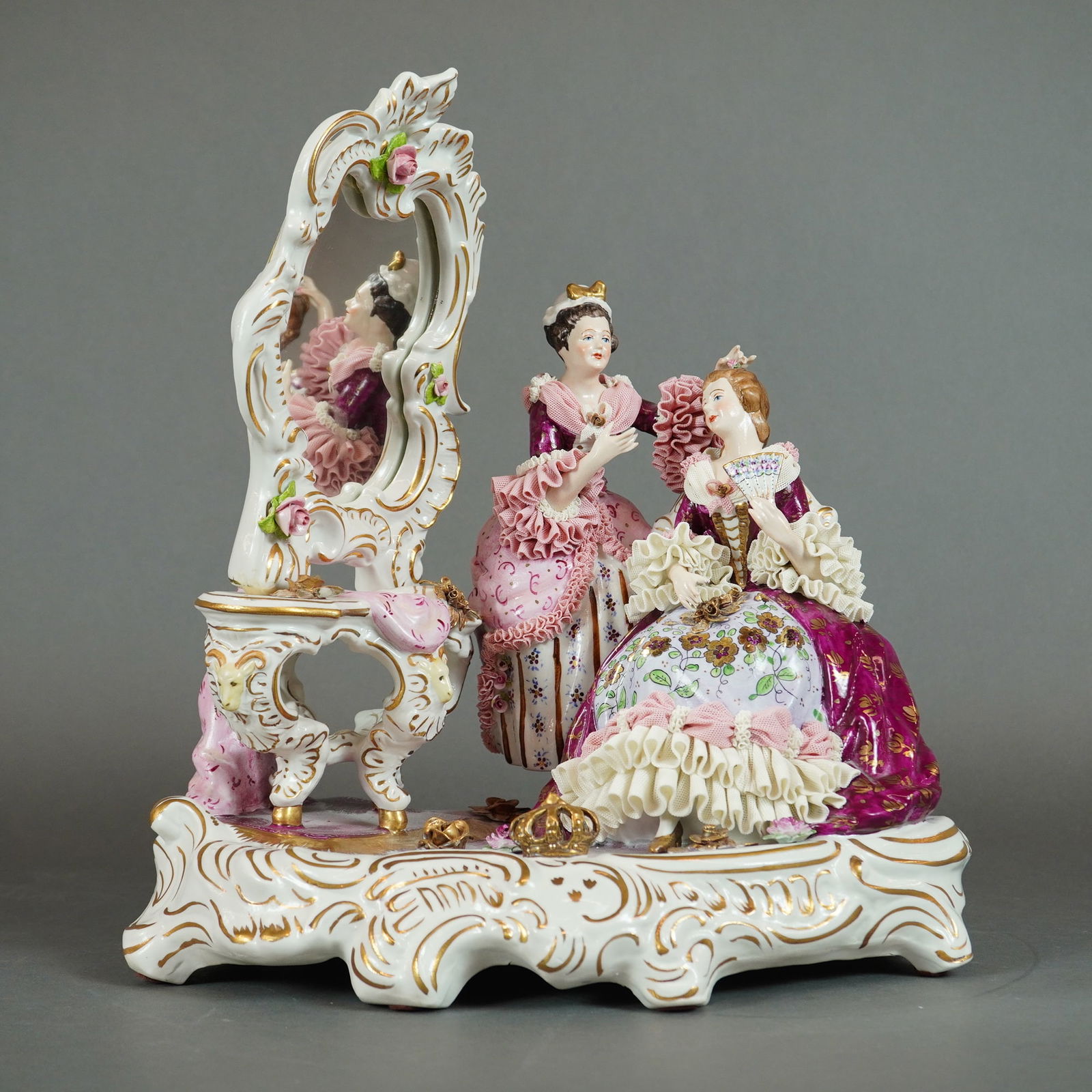 Dresden Porcelain Lace Figural Group Depicting a Dressing Scene: A single Dresden Porcelain sculpture figural group, executed in the Rococo Revival style. The piece depicts a dressing scene featuring two female figures in elaborate 18th-century style gowns. The fig