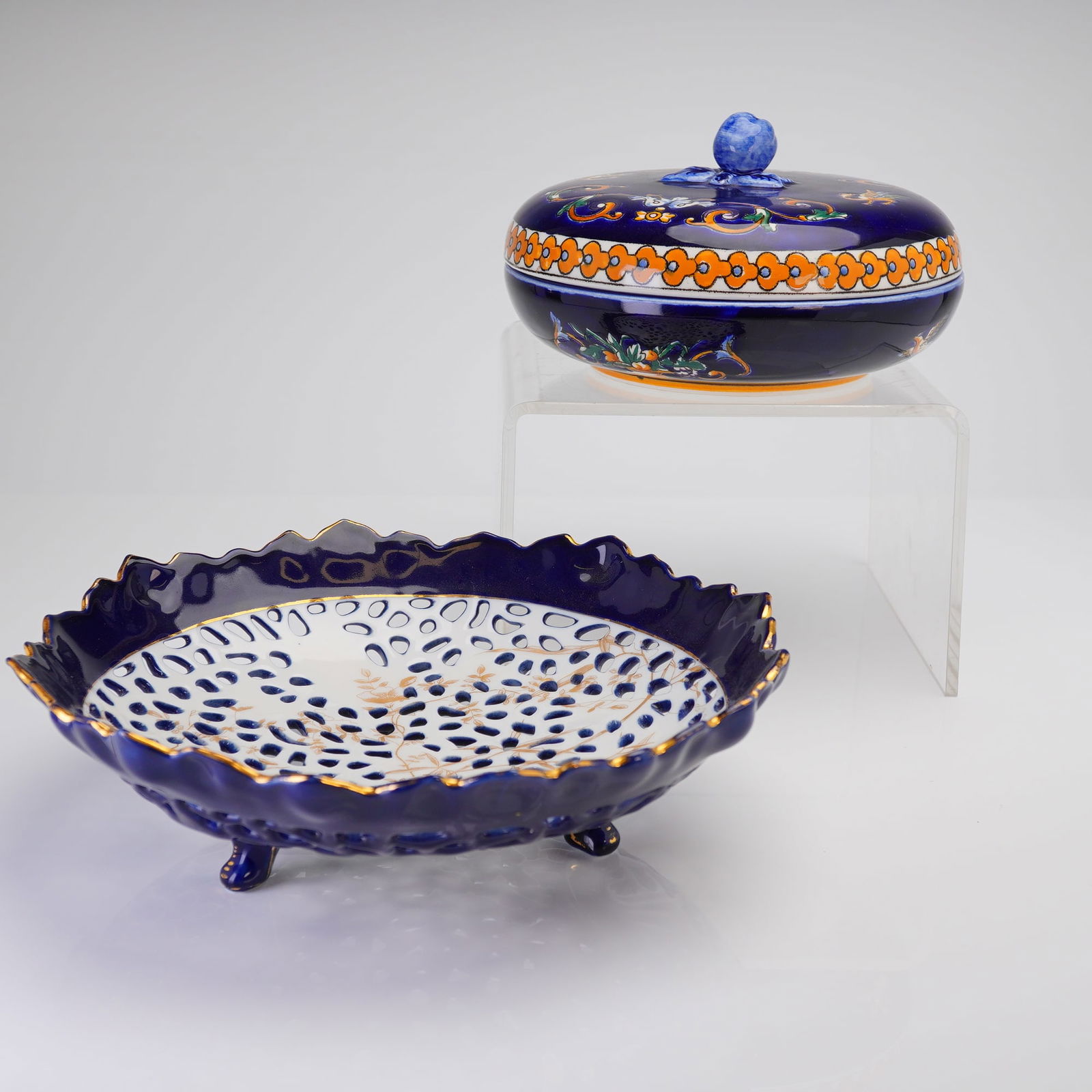 A Pair of Gien Faience Bonbonniere and Vented Candy Dish: This two-piece lot of Gien faience earthenware comprises a covered bonbonniere and a footed vented candy dish. Both pieces are executed in a deep cobalt blue glaze accented with extensive gold gilt de