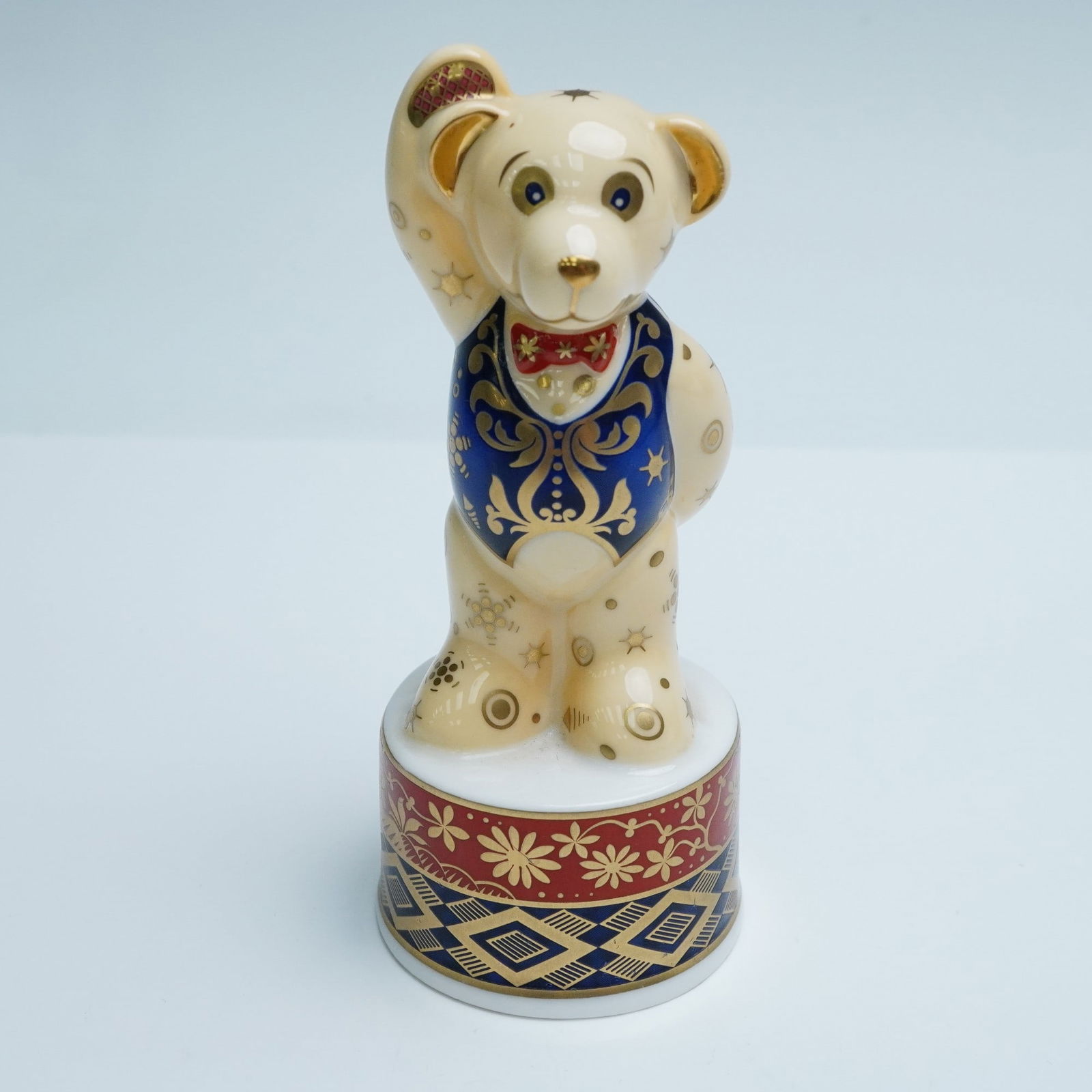 Royal Worcester Porcelain Candle Snuffer, Prince Regent Teddy Bear: A richly decorated porcelain candle snuffer from The Connoisseur Collection. This celebratory figure features intricate geometric and floral designs throughout. The bear stands with one hand above its