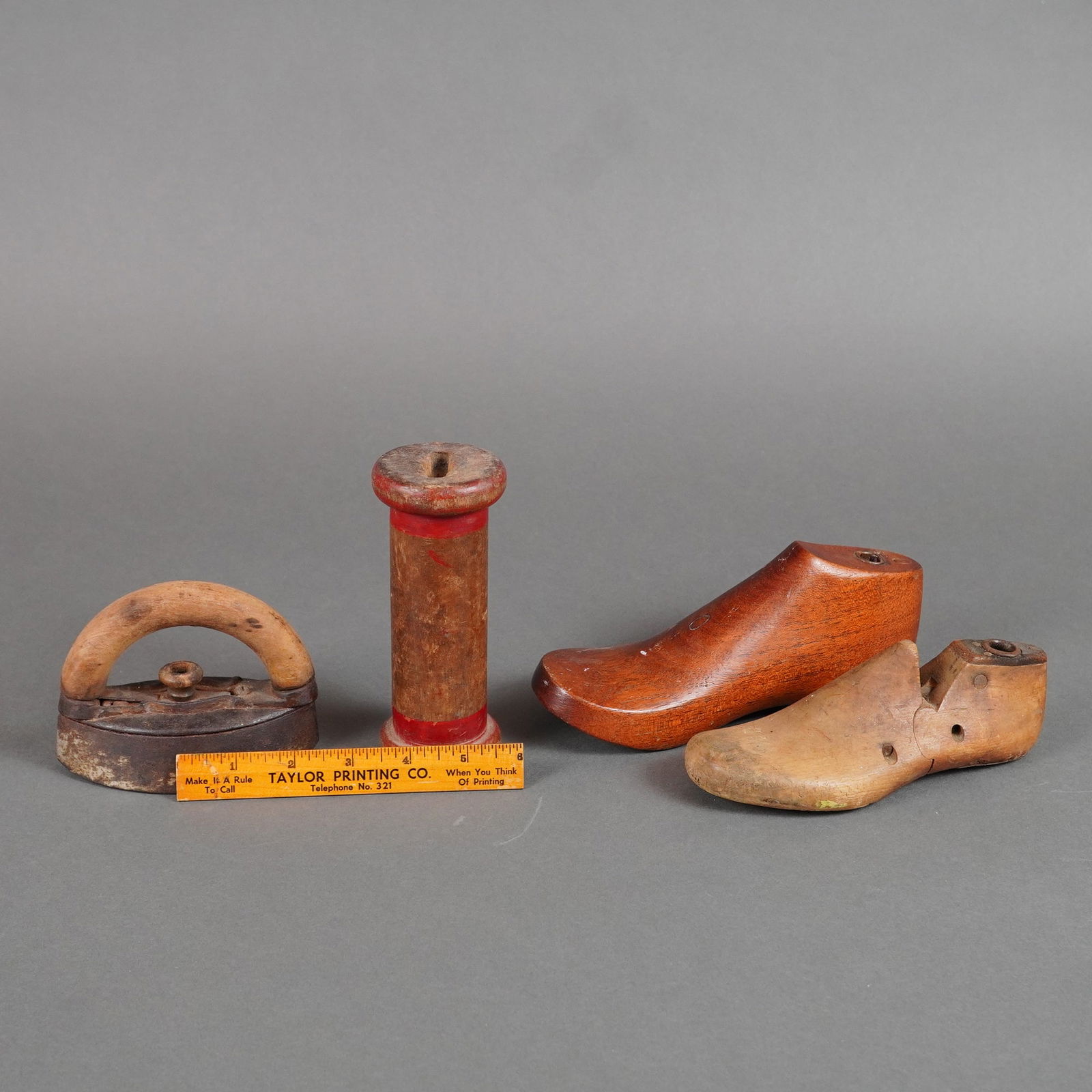 5pc Cobbler Implements including Wood Forms, Spool, & More: Primarily constructed from wood and cast iron. The collection includes two child's wooden shoe forms. One form is constructed of polished reddish-brown hardwood, exhibiting a smooth surface. The secon