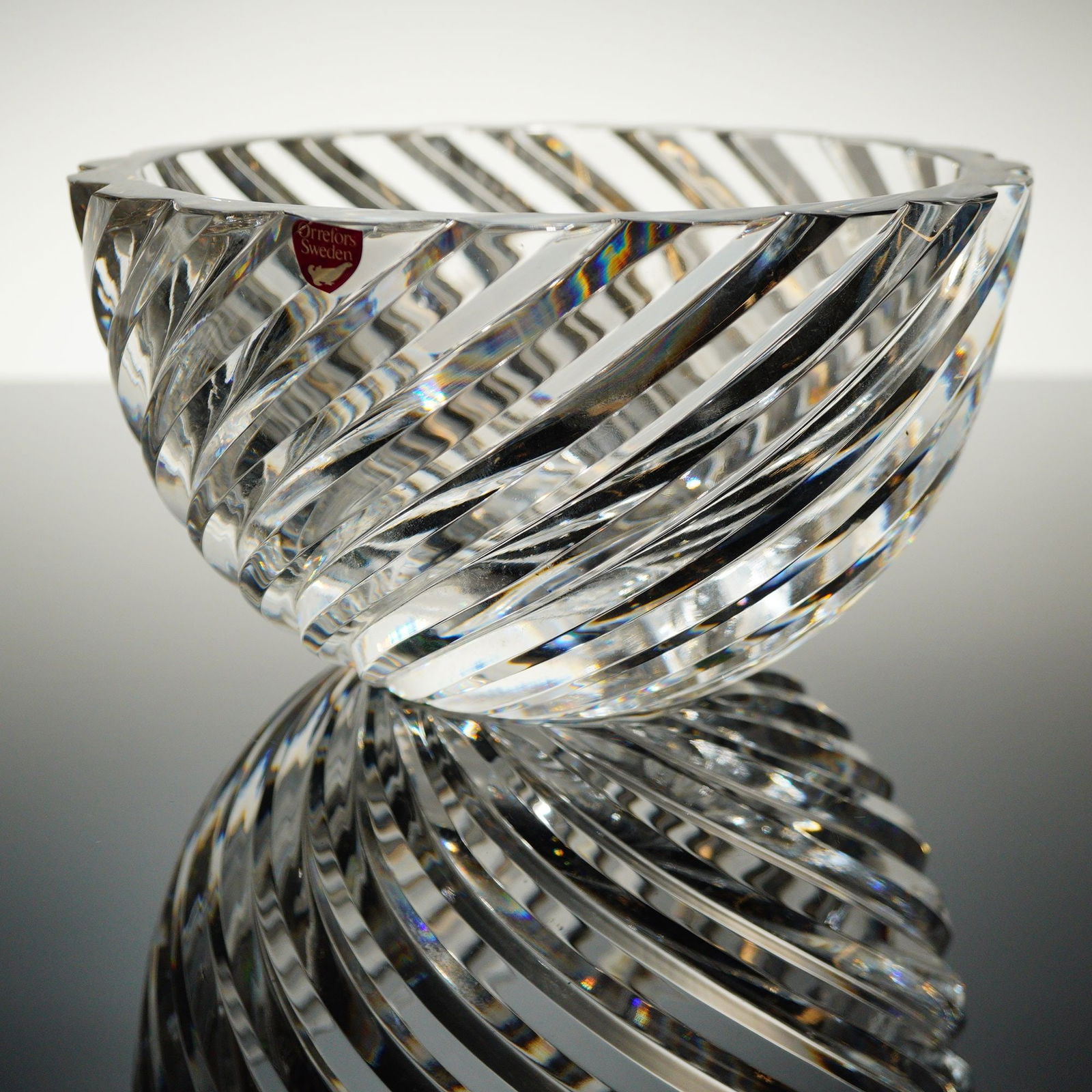 Jan Johansson for Orrefors Svaneholm Crystal Bowl: A heavy crystal bowl, identified as the Svaneholm patern designed by Jan Johansson for Orrefors. The clear crystal features a distinct, deep-cut spiral or vortex patern encompassing both the exterio