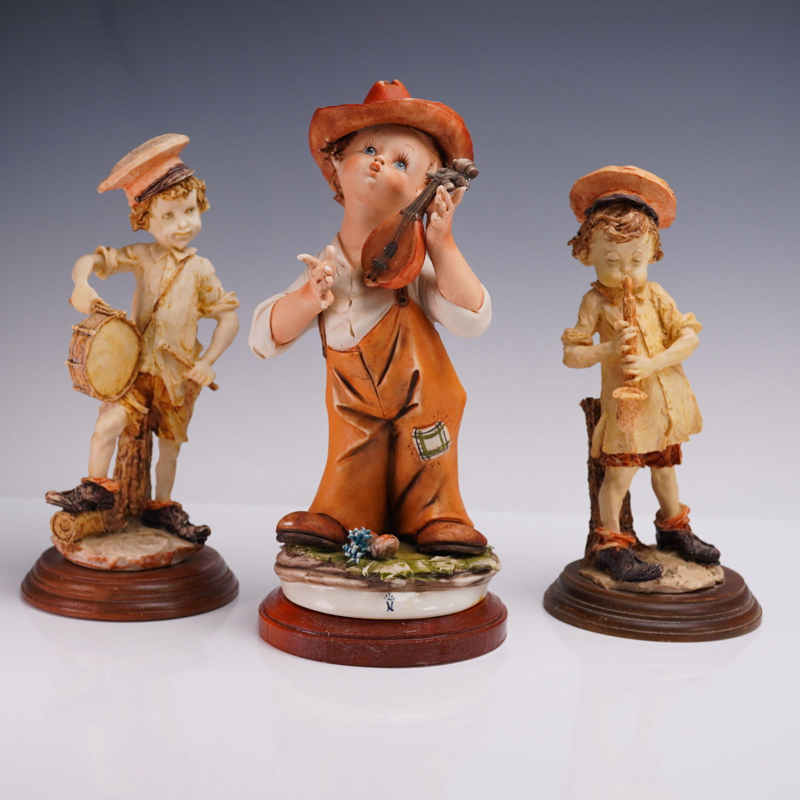 3pc Italian Figurine Lot Children Playing Instruments: Charming 3-piece set of vintage-style Italian figurines depicting children playing musical instruments. Each figure is individually sculpted and painted with expressive features and nostalgic detail,