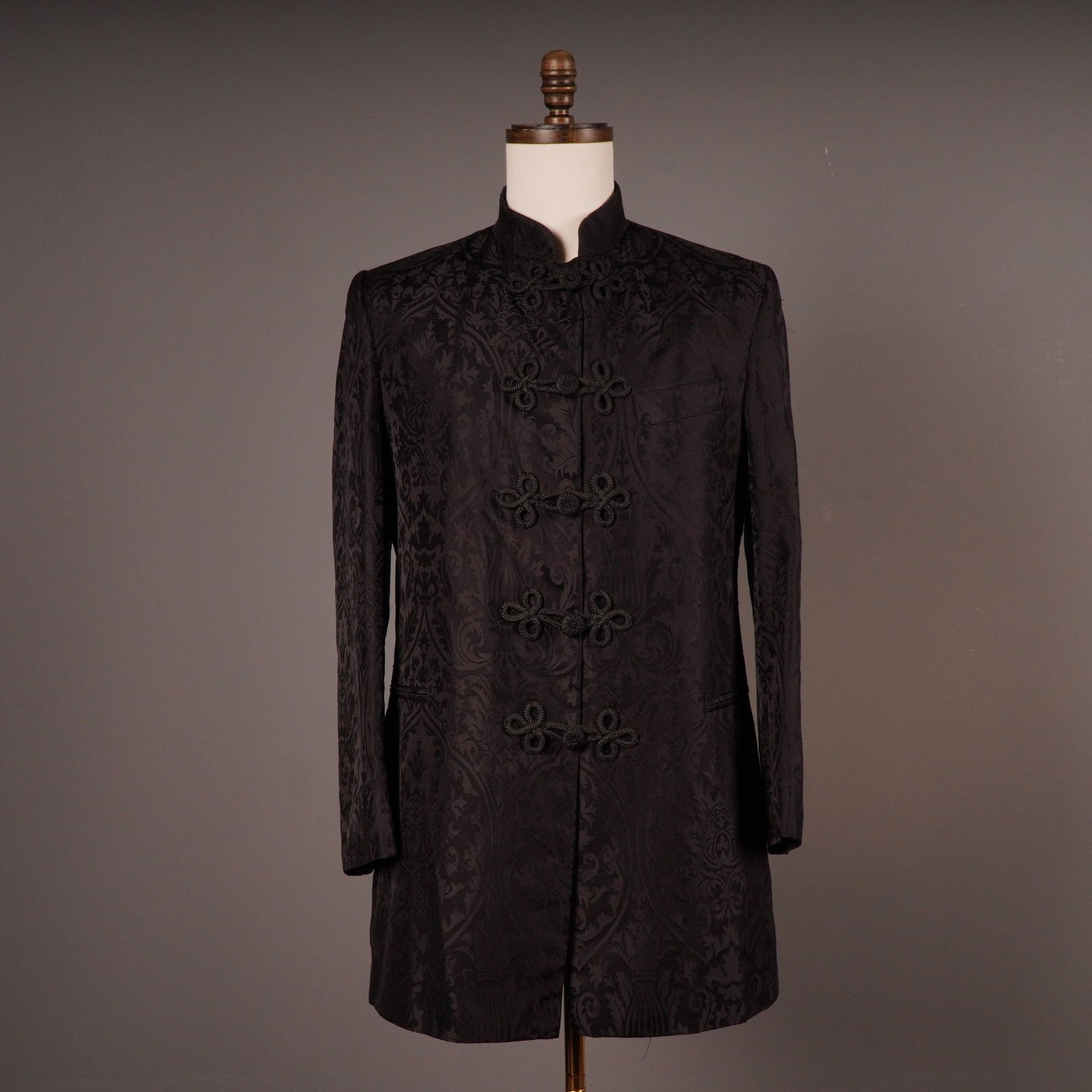 Favourbrook London Men's Black Silk Nehru-Collared Jacket: A contemporary men's long coat or jacket by Favourbrook, constructed from 100% black silk. The garment features a high stand-up (Nehru) collar and a center-front closure with four black knotted frog f