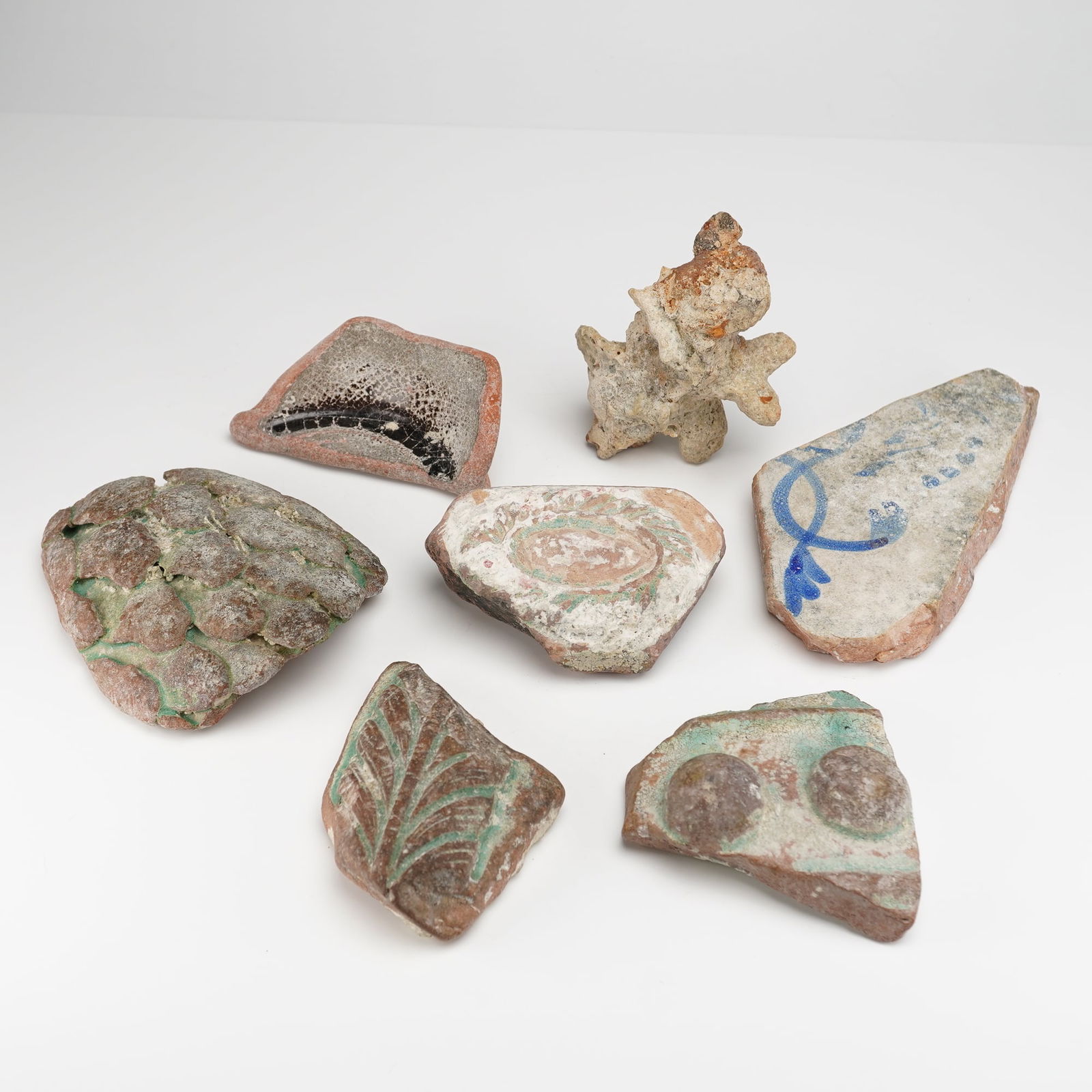 7pc Fossilized Pottery Fragments (Shards): Fossilized fragments with pottery shards, composed of reddish-brown earthenware or terracotta clay. Decorative techniques observed include partial relief modeling, impressed motifs, and painting or gl