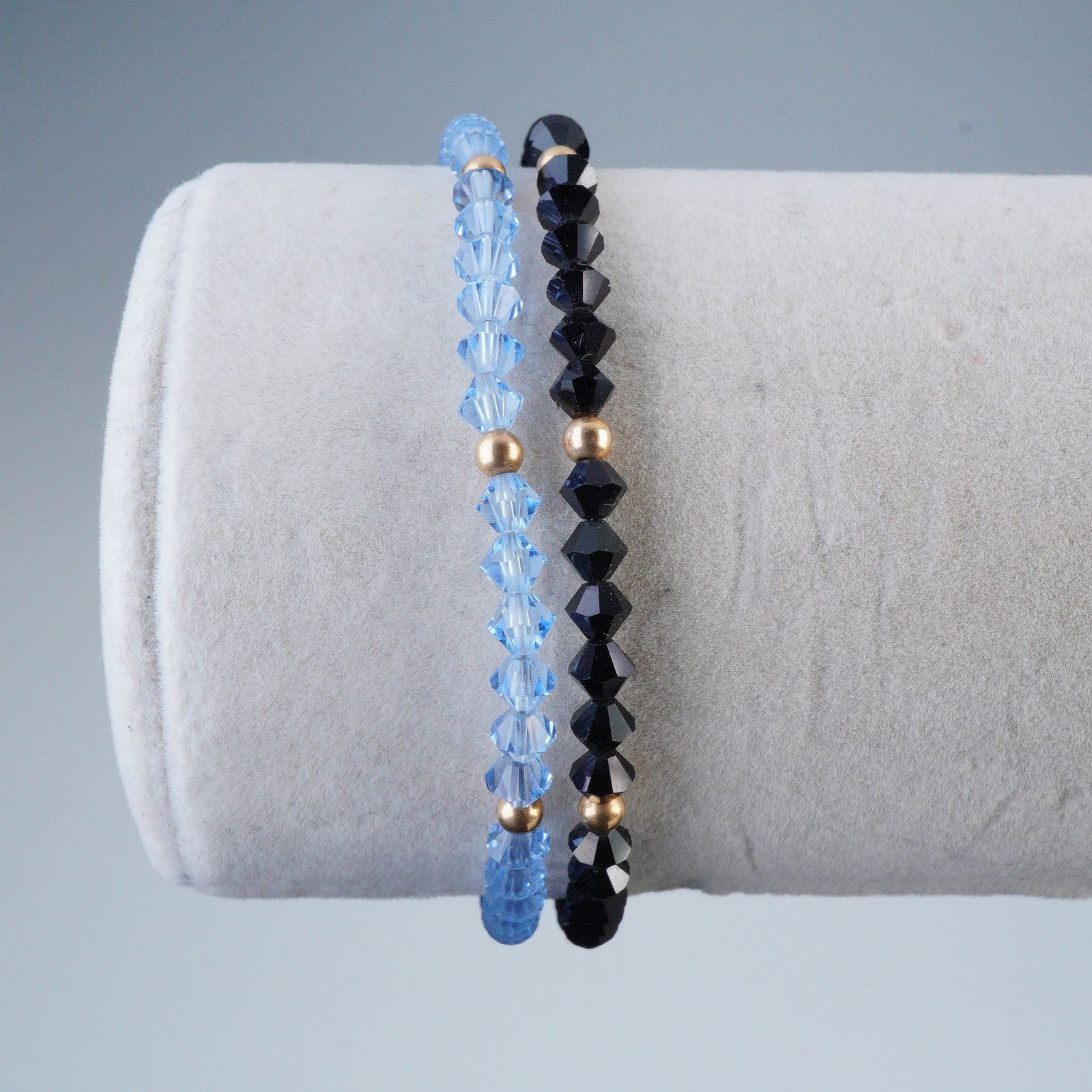 2pc Crystal and Black Tourmaline Beaded Bracelets with 14K Links: This lot comprises a pair of beaded bracelets, including one featuring numerous uniformly sized faceted translucent light blue crystal beads, interspersed with small, round, gold-toned spacer beads. T
