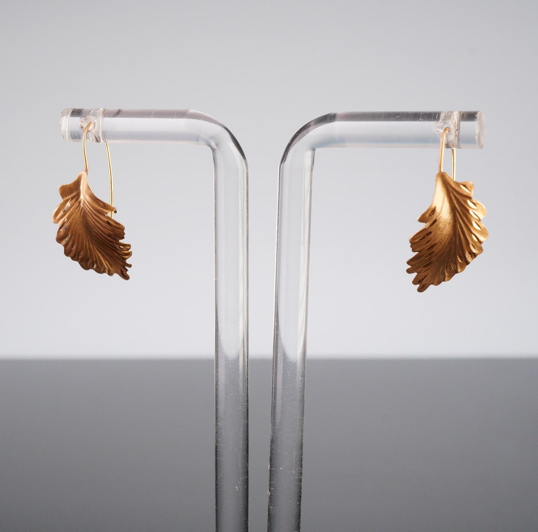 14K Gold JCM Jacmel Mauritius Leaf-Shaped Drop Earrings: A pair of drop earrings by JCM Jacmel Mauritius each featuring a sculptural, naturalistic leaf motif, reminiscent of an oak leaf, with detailed venation and serrated edges. Ear hooks are stamped JCM 1