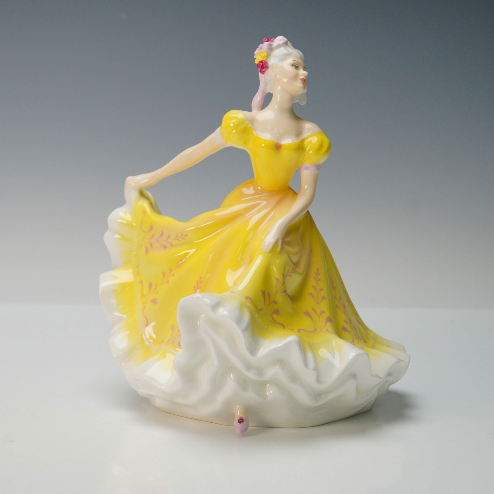 Royal Doulton Figurine, Ninette HN2379: Part of Peggy Davies series. Woman in yellow and white dress. Floral headpiece on side of head. Royal Doulton backstamp. Artist: Peggy Davies Issued: 1971 - 1997 Dimensions: 6.75"L x 6"W x 8.25"H Coun
