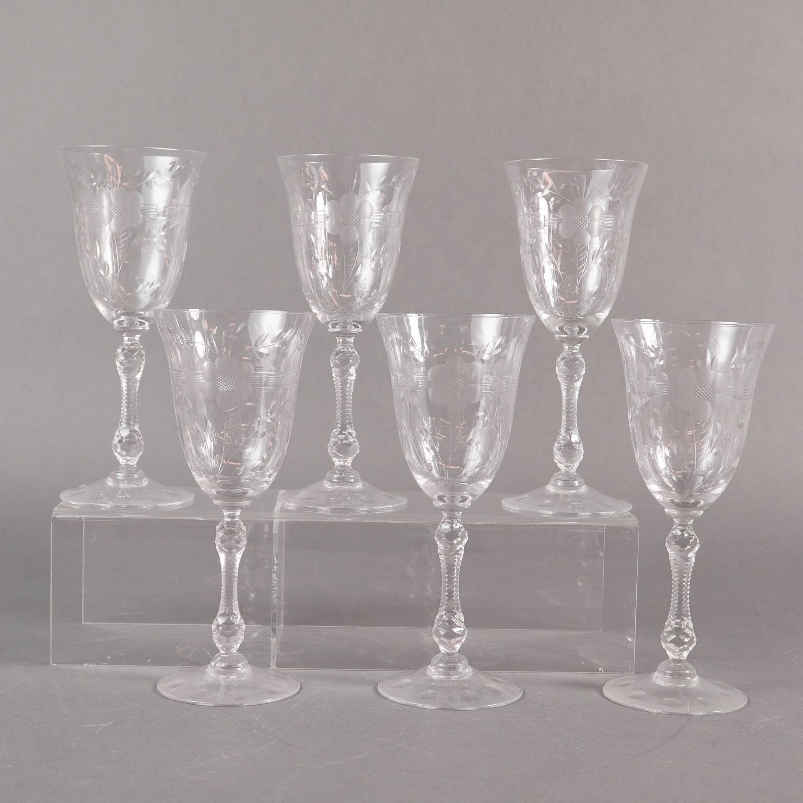 A Collection of Six Cambridge Lucia Crystal Water Goblets: A collection of six Cambridge Lucia cut crystal water goblets. These pieces feature a flared, bell-shaped bowl decorated with an intricate wheel-cut or etched pattern depicting repeating floral and fo