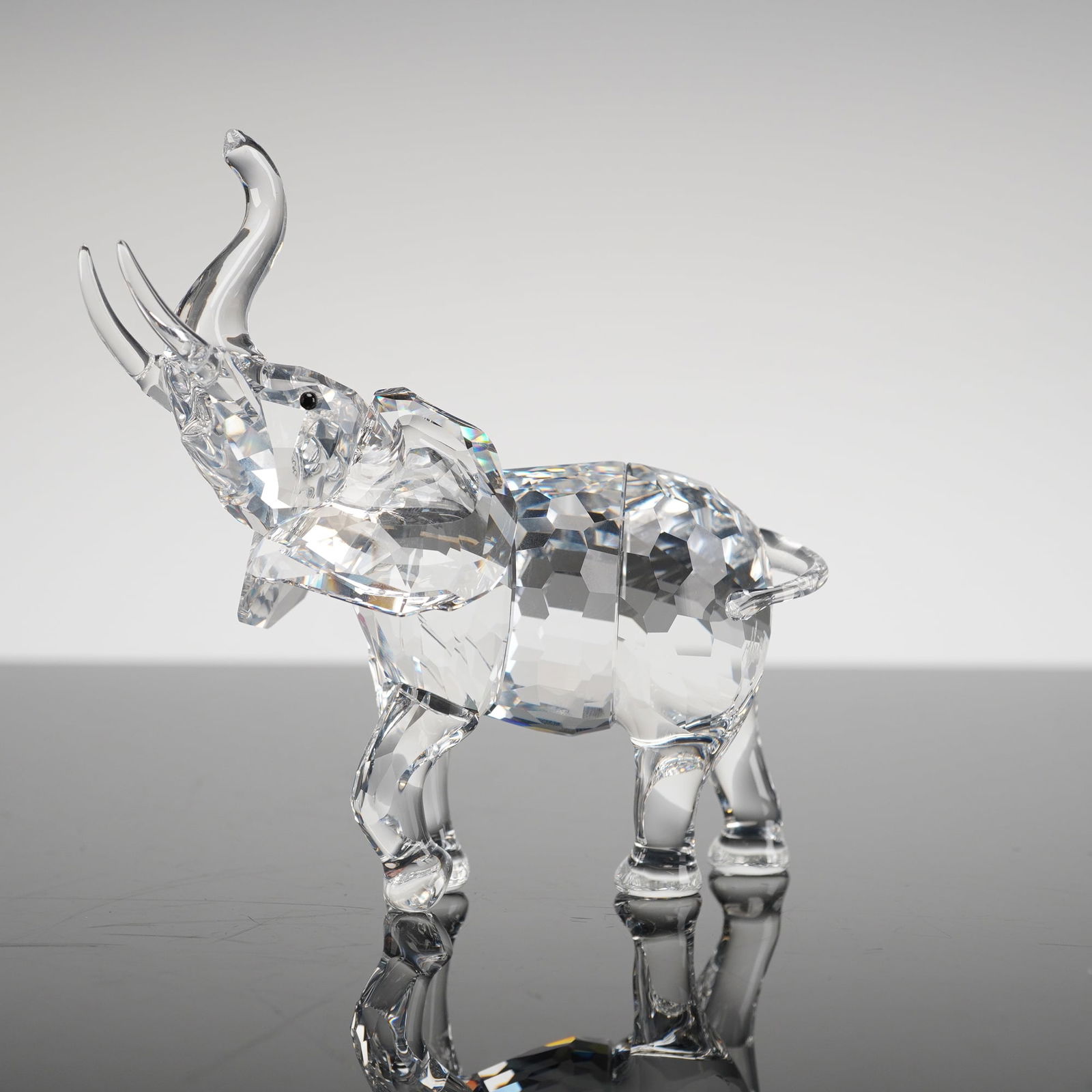 Signed Swarovski Elephant Mother Crystal Figurine: A single Swarovski crystal figurine identified as the Elephant Mother, Model 678945, signed by artist Heinz Tabertshofer. The contemporary faceted crystal figurine is executed in clear, colorless crys