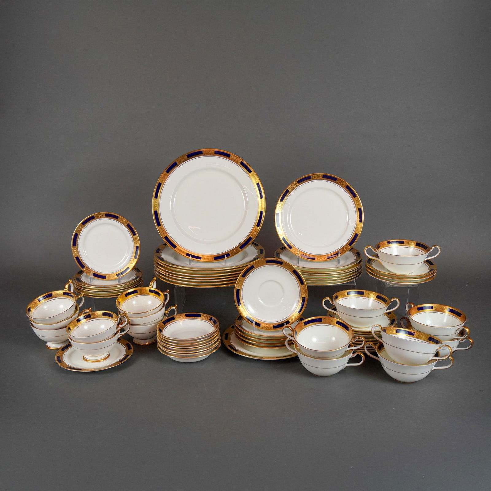 A Collection of 78 Pieces Aynsley Empress Cobalt Partial Dinner Service: A collection of 78 pieces of English bone china partial tableware service manufactured by Aynsley in the Empress Cobalt pattern. The service is comprised of 60 pieces of flatware (various sized plates