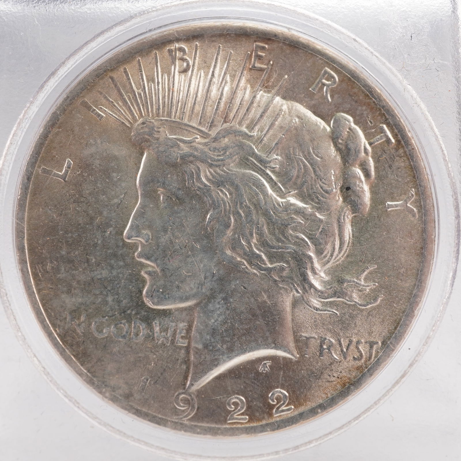 1922 Peace Dollar Silver Coin: The 1922 Peace Dollar is struck in .900 fine silver. The obverse features a capped head of Liberty facing left, with a headband adorned with rays. The Latin inscriptions read LIBERTY, IN GOD WE TRVST,