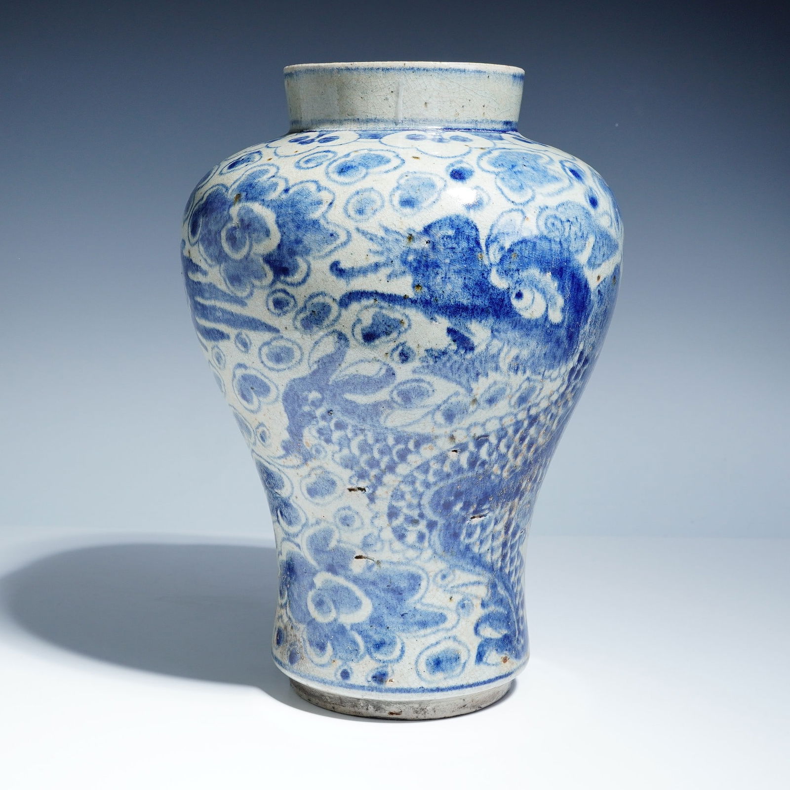Korean Joseon Period Blue and White Dragon Vase: The baluster-form vessel features underglaze cobalt blue decoration depicting a continuous scene of a four-clawed, scaly dragon chasing a flaming pearl amid stylized cloud motifs. The surface is finis