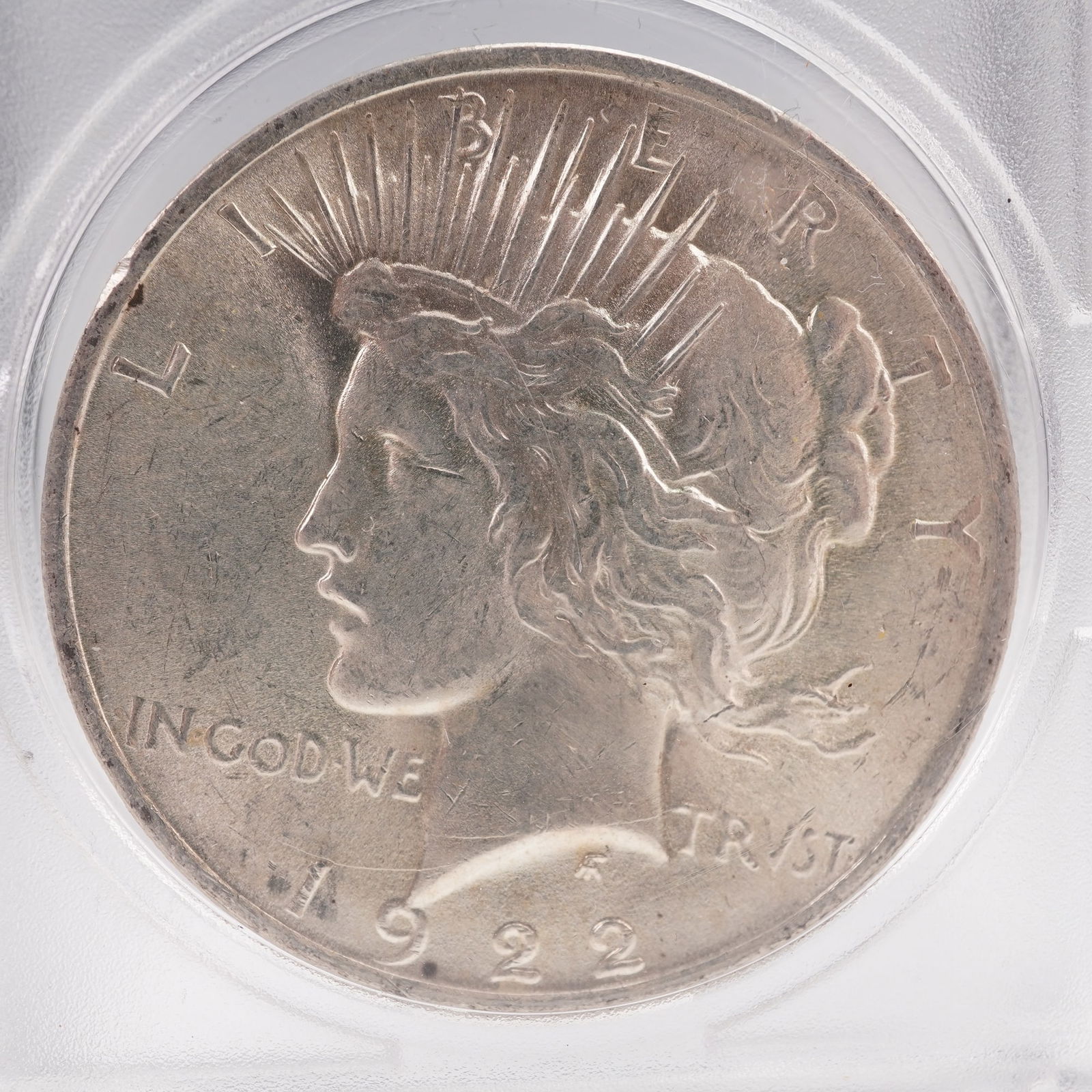 1922 Peace Dollar Silver Coin: The 1922 Peace Dollar is struck in .900 fine silver. No mint mark. The obverse features a capped head of Liberty facing left, with a headband adorned with rays. The Latin inscriptions read LIBERTY, IN