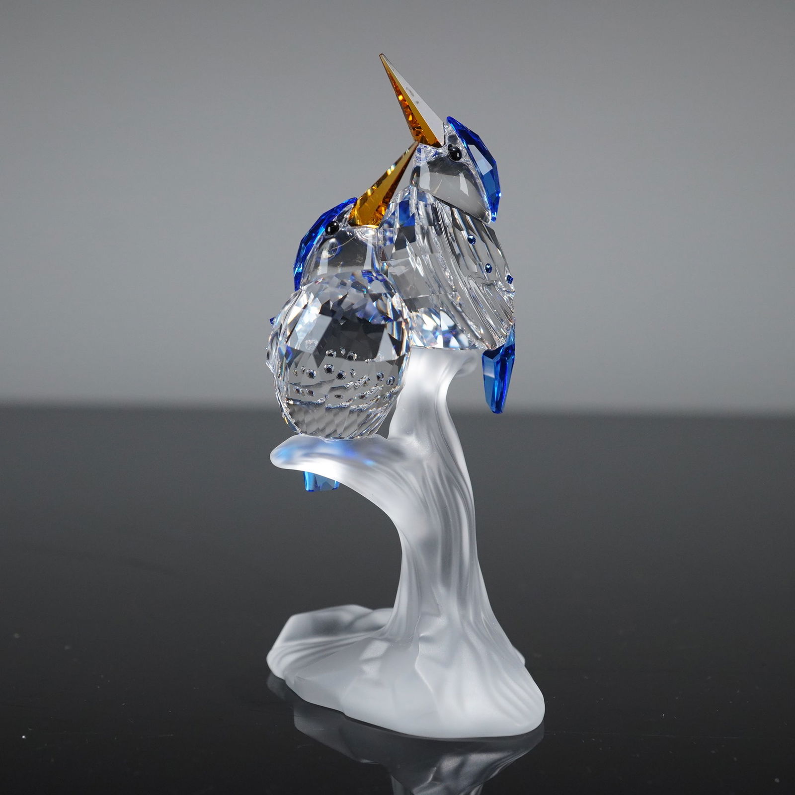 Swarovski Crystal Figurine Malachite Kingfishers: A single Swarovski Crystal Figurine, identified by the stock number 623323, known as the Malachite Kingfishers model. The sculpture features two stylized kingfisher birds perched upon a frosted satin