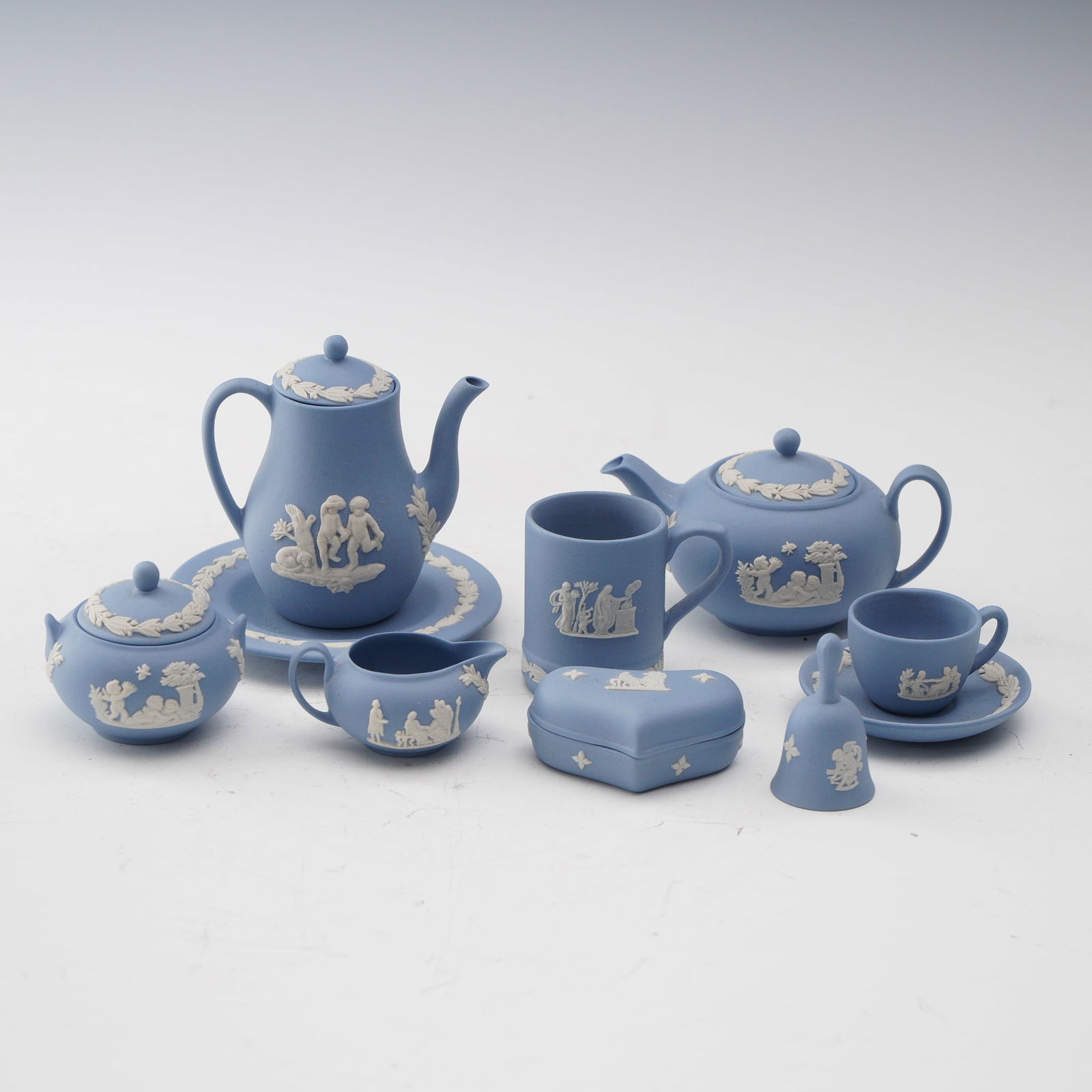 14pc Wedgwood Blue Jasperware Tea Set Miniatures: Charming collection of fourteen Wedgwood Jasperware miniatures in the iconic blue and white palette, including teapots, sugar, creamer, cups, saucers, bell, and a lidded trinket box. Each piece is dec