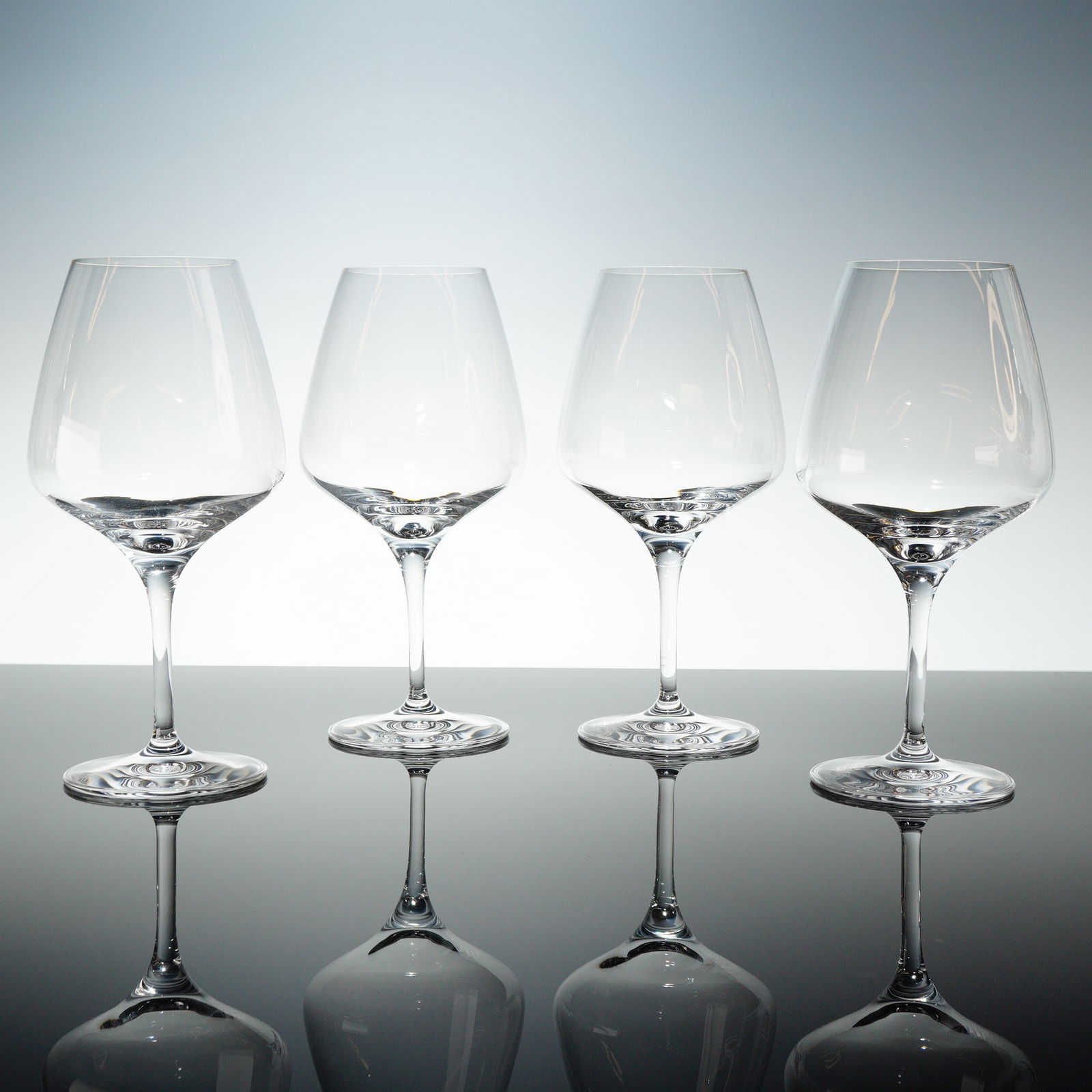 Set of Four Orrefors Pulse Crystal Wine Glasses Designed by Ingegerd Raman: A set of four Orrefors Pulse Crystal wine glasses, designed by Ingegerd Raman. These modern, contemporary pulse wine glasses feature a tall, sleek stem supporting a generous, tapered bowl. The clear c
