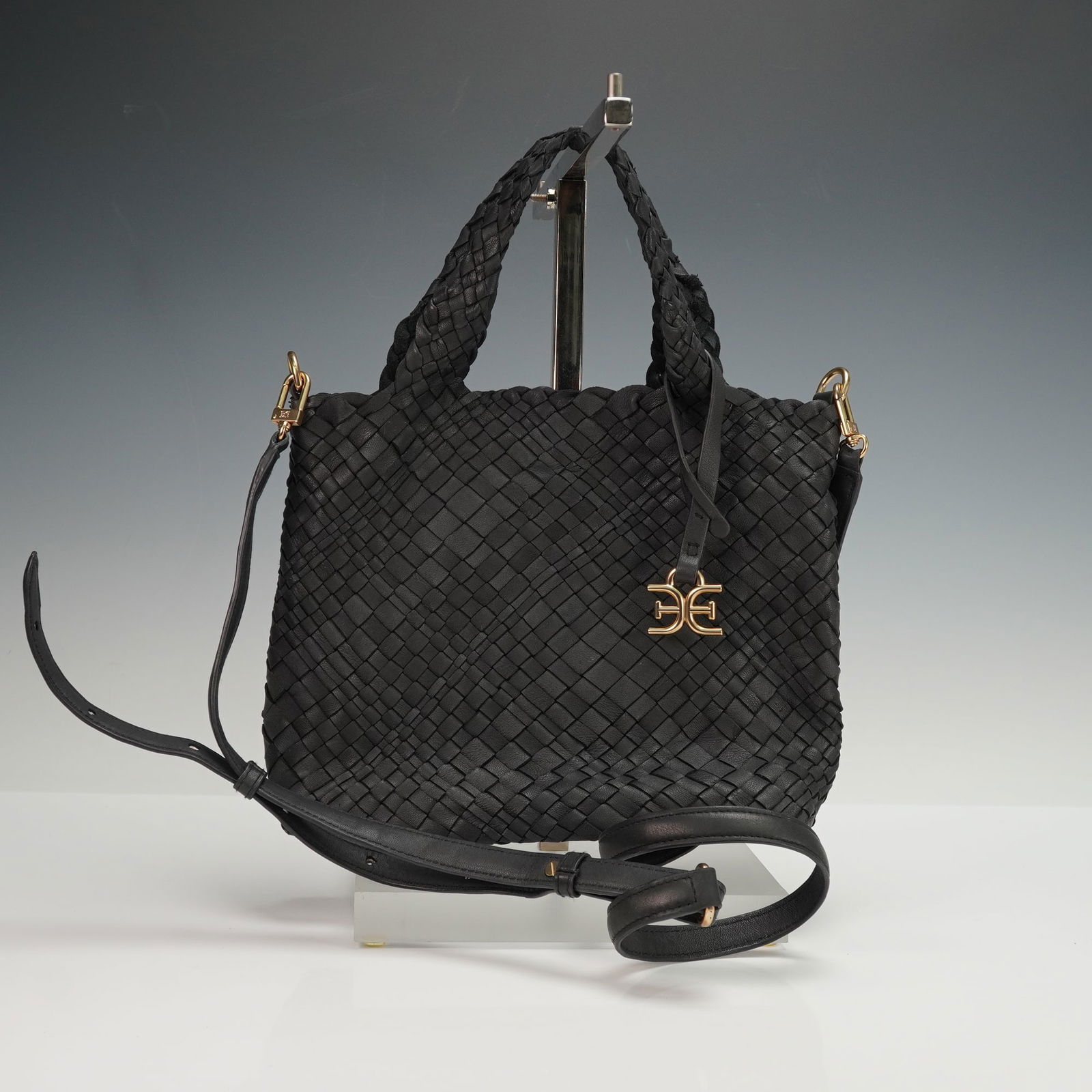 Sam Edelman Priya Black Woven Leather Shoulder Tote Bag: A Sam Edelman Priya Woven Leather Tote bag with a modern black woven design and featuring an intrecciato-style body with two braided top handles and a detachable, adjustable shoulder strap. All hardwa