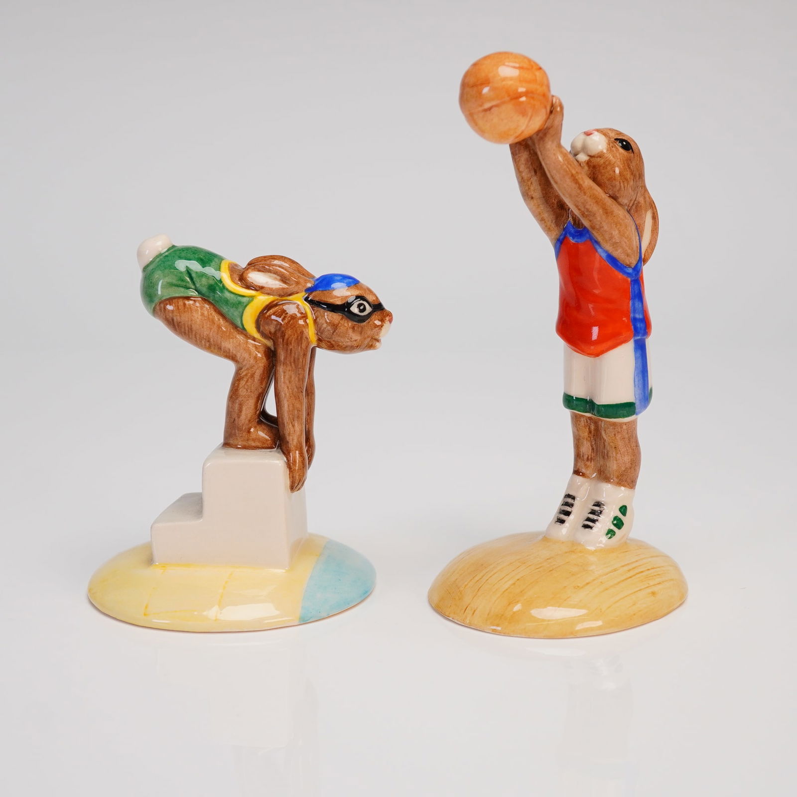 A Pair of Royal Doulton Bunnykins Limited Edition Sports Figurines: A pair of Royal Doulton Bunnykins limited edition sports figurines, executed in glazed bone china. These anthropomorphic rabbit figures are part of the Games Collection, depicting sporting activities.