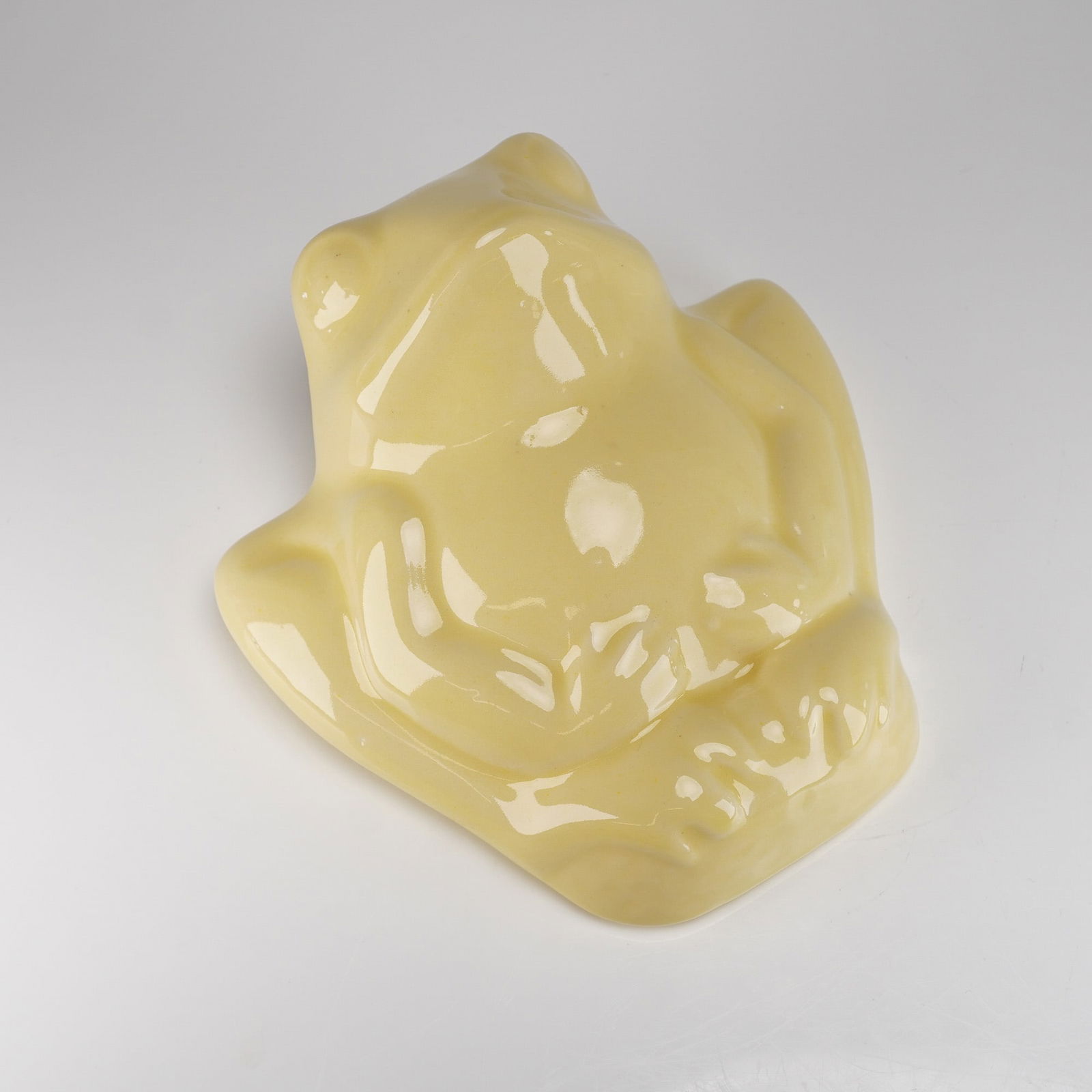 McCoy Pottery Yellow Frog Wall Pocket: A single ceramic wall pocket manufactured by McCoy Pottery, modeled in the form of a plump, stylized sitting frog. The piece is covered in a high-gloss pale yellow (custard) glaze. This vintage McCoy