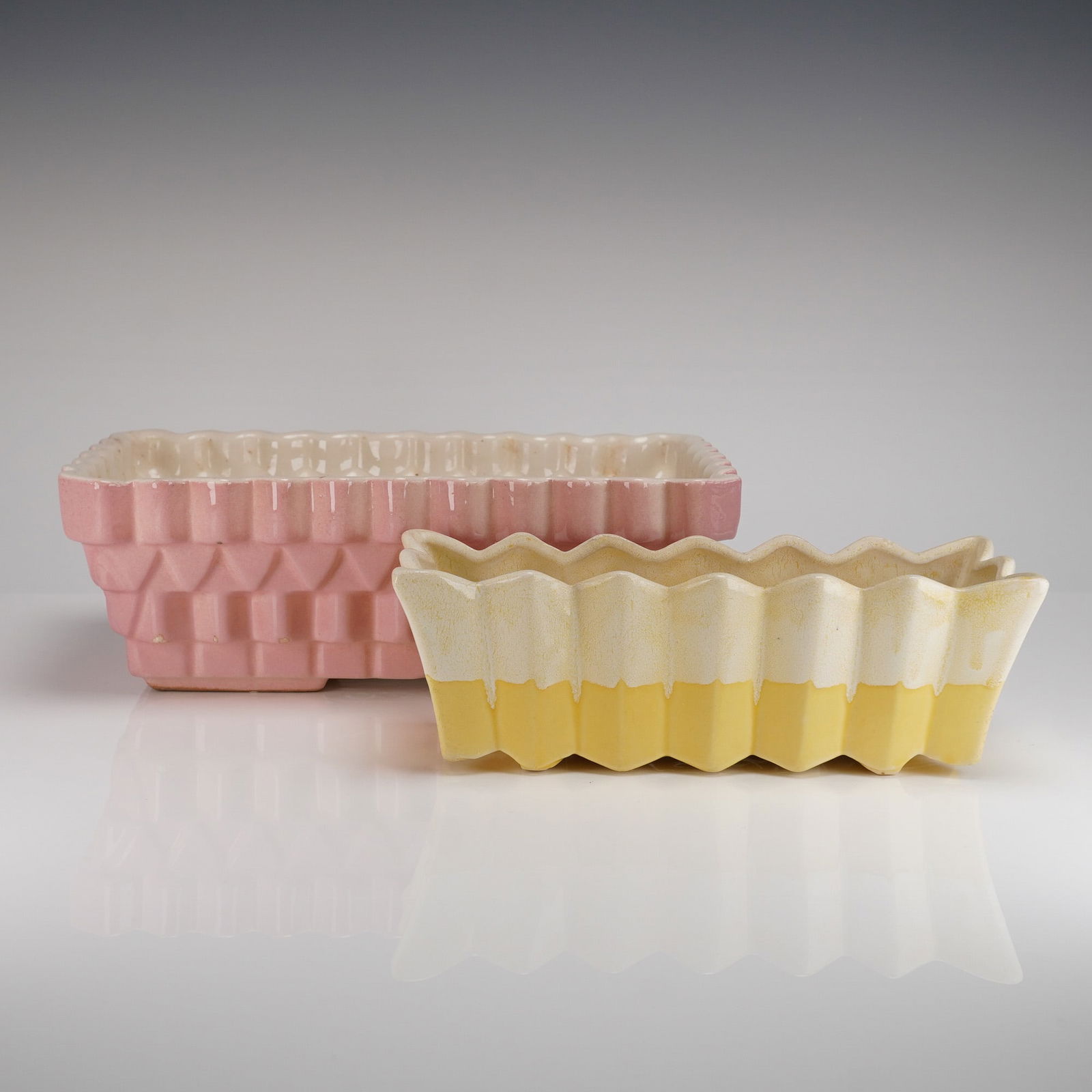 A Pair of McCoy Mid-Century Rectangle Jardinieres: A pair of Mid-Century American glazed ceramic rectangular jardinieres attributed to McCoy Pottery. The collection consists of two distinct pieces of art pottery. The first, larger planter features a r