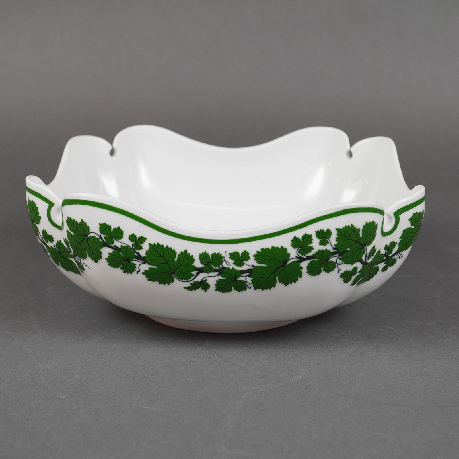 Meissen Full Green Vine Scalloped Square Serving Bowl: A single porcelain serving bowl manufactured by the Meissen Royal Porcelain Manufactory, featuring the recognized Full Green Vine pattern. The bowl is constructed of white glazed porcelain in a square