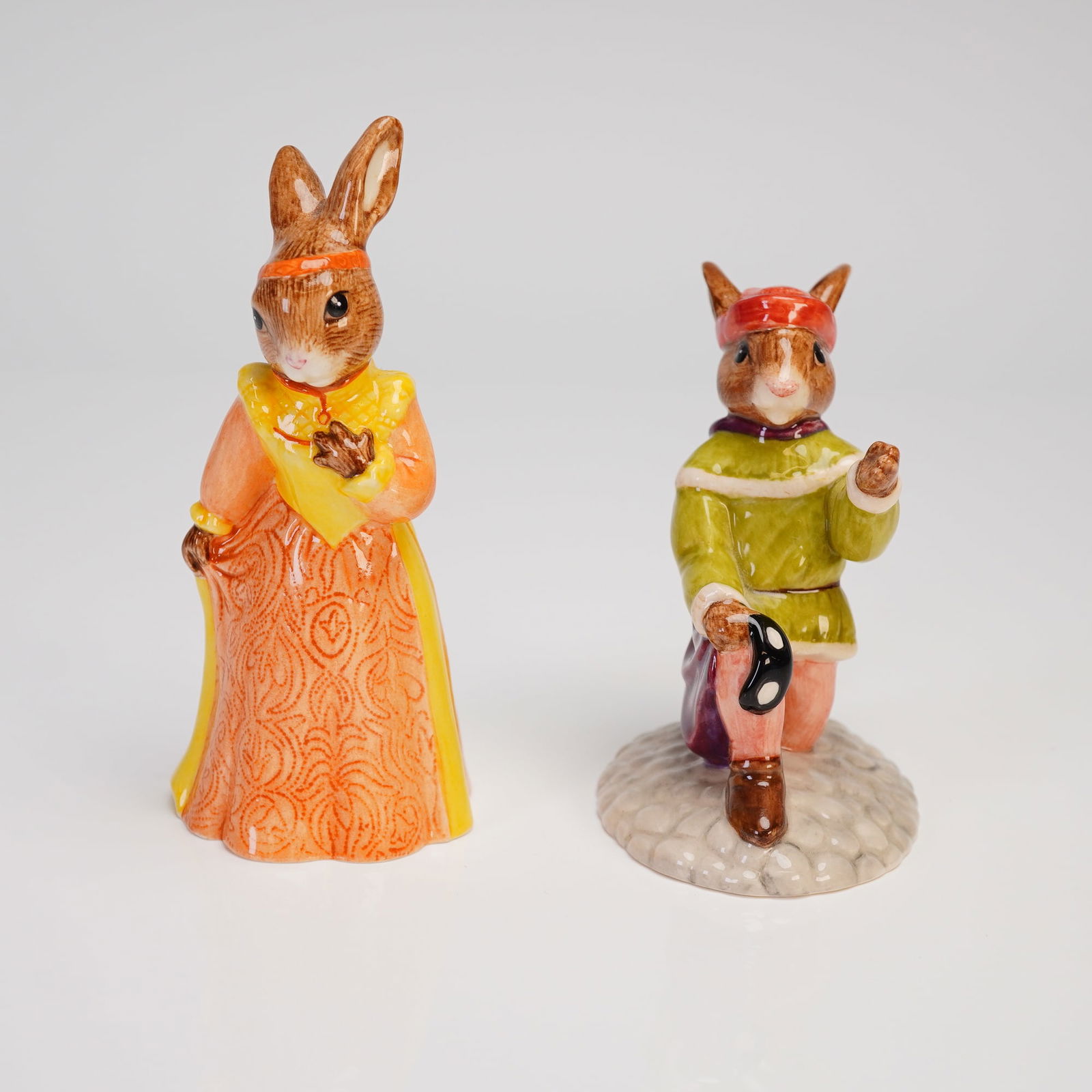 A Pair of Royal Doulton Bunnykins Romeo and Juliet Figurines: A pair of Royal Doulton Bunnykins ceramic figurines, depicting the characters Romeo (DB 284) and Juliet (DB 283). The hand-made and hand-decorated figures portray rabbits in theatrical attire. Juliet