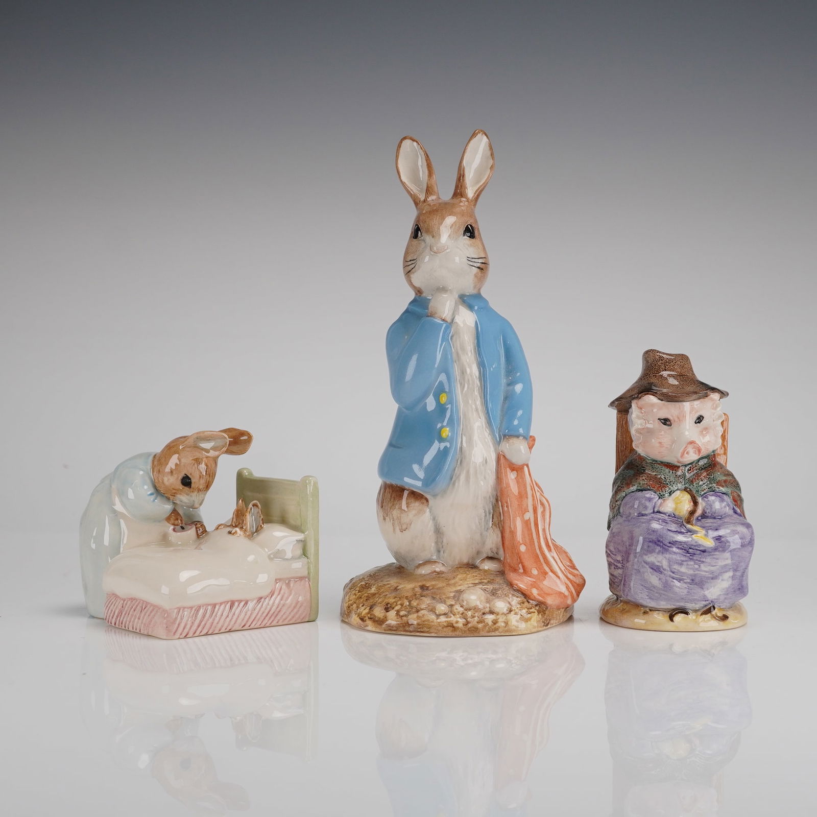 Three Royal Albert Beatrix Potter Porcelain Figurines: A 3-piece collection of Royal Albert porcelain figurines depicting characters from the tales of Beatrix Potter. The figurines are executed in glazed ceramic with polychrome enamels. The collection