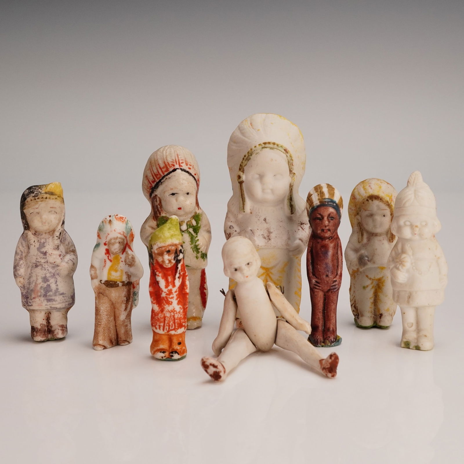 9pc Old Porcelain Dolls, Marked Japan Miniatures: This 9 piece collection of old porcelain dolls includes an adorable assortment of miniature figures, many marked Japan, indicating their origin during the early to mid 20th century when Japan was