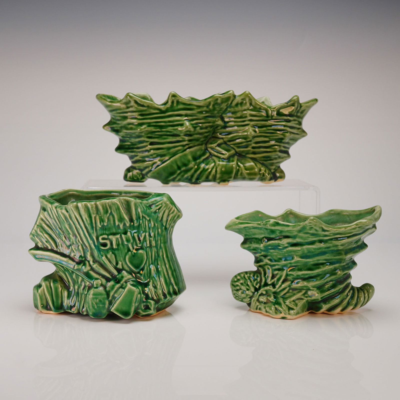 Three McCoy Emerald Green Glazed Earthenware Planters: A three-piece collection of ceramic vessels attributed to McCoy, consistent with the style of their novelty planters or cachepots. The set includes one rectangular centerpiece vessel and two smaller,
