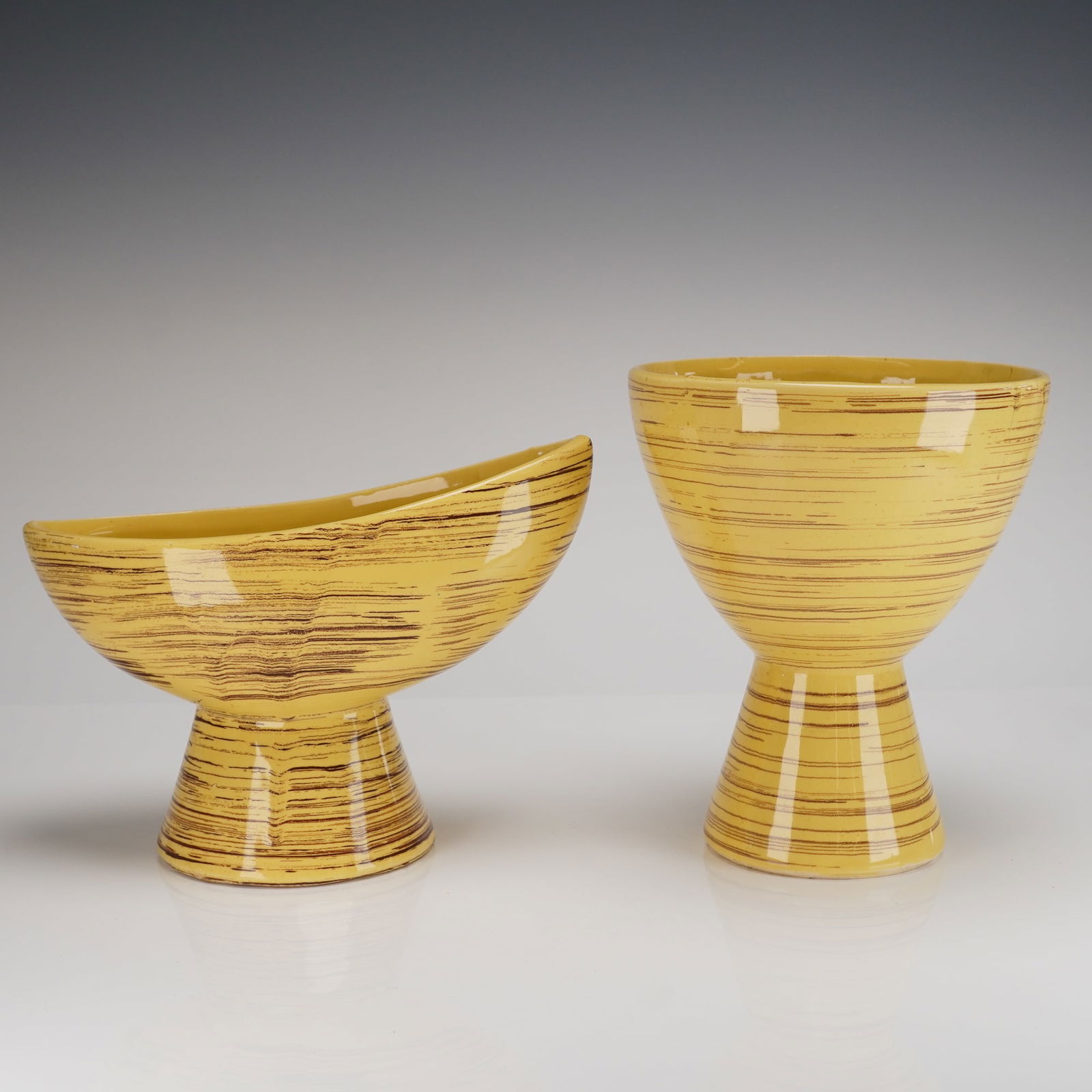 2pc McCoy Pottery Yellow and Brown Striped Footed Vessels: Two vintage McCoy Pottery footed ceramic vessels, consistent with mid-century modern design. The 2pc set includes a tall, tapered vase-like form and a lower, elongated, asymmetrical boat-shaped bowl.