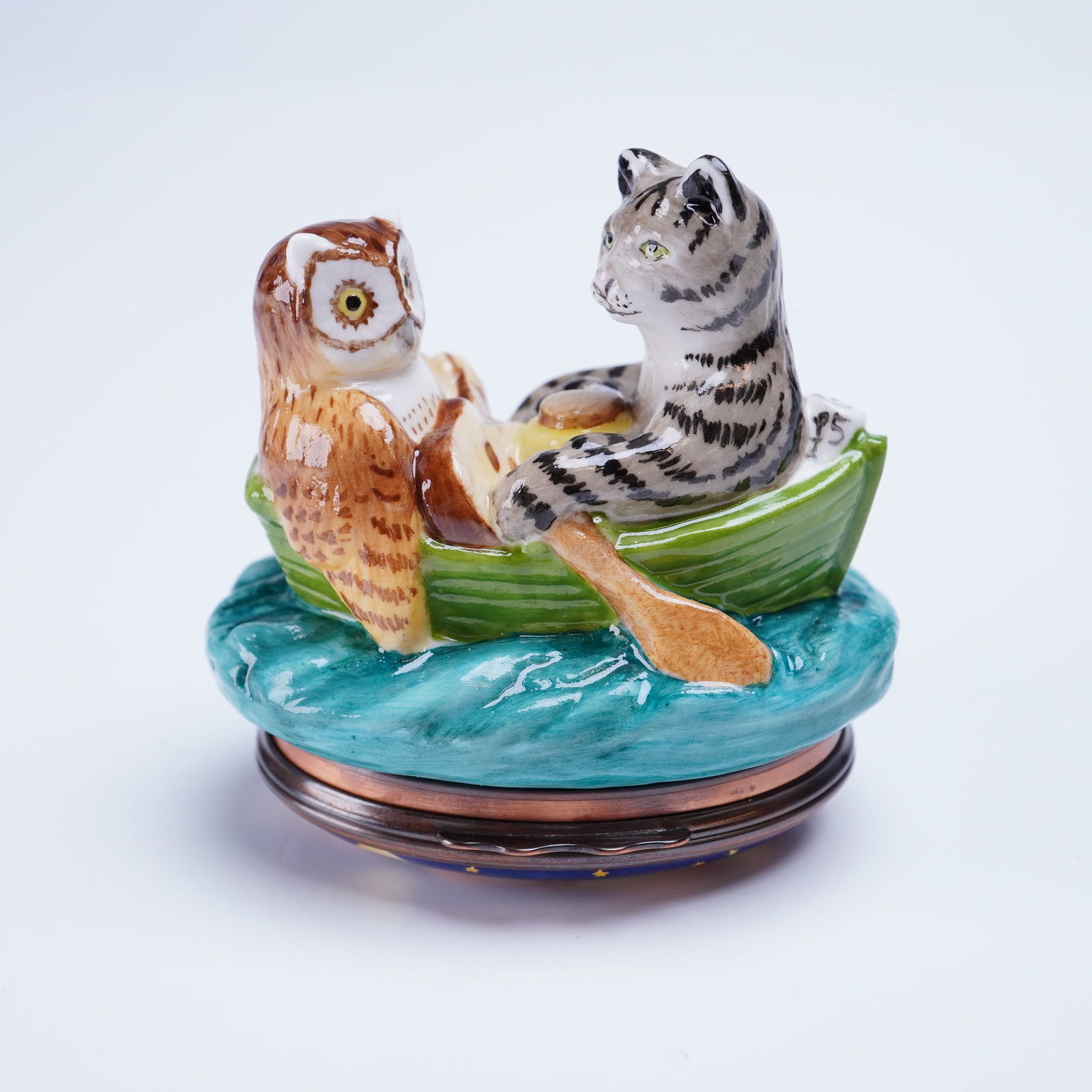 Halcyon Days London Enamel Trinket Box Owl and the Pussycat: A single hinged trinket box by Halcyon Days London, based on the Edward Lear poem, The Owl and the Pussy-Cat. The box features a figural enameled porcelain top depicting an owl and a striped cat