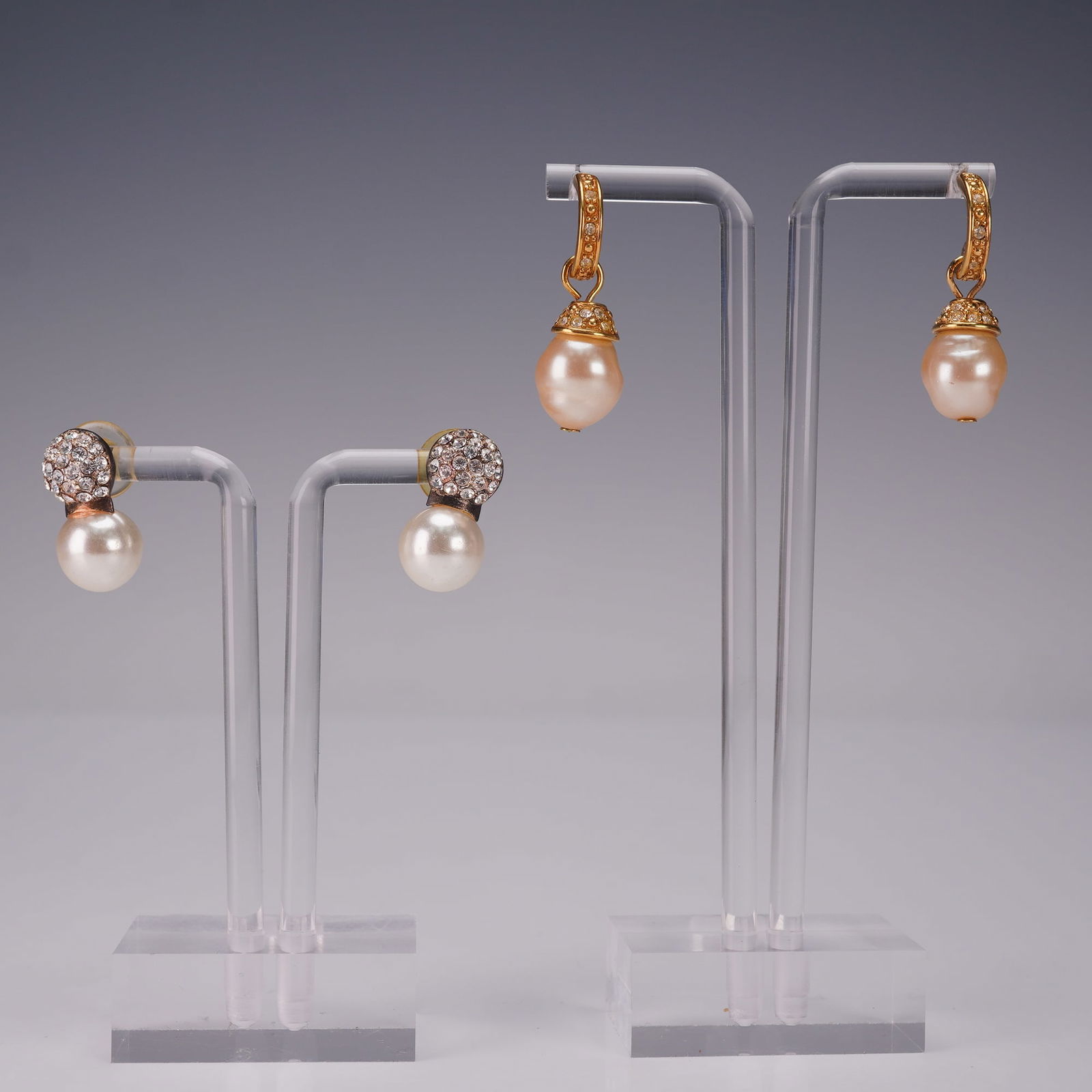 2 Pair Rhinestone and Faux Pearl Earrings: Group of two pairs of glamorous rhinestone accented earrings. The first pair features luminous faux pearls suspended from pave rhinestone caps set in a goldtone mount, offering a chic drop design.