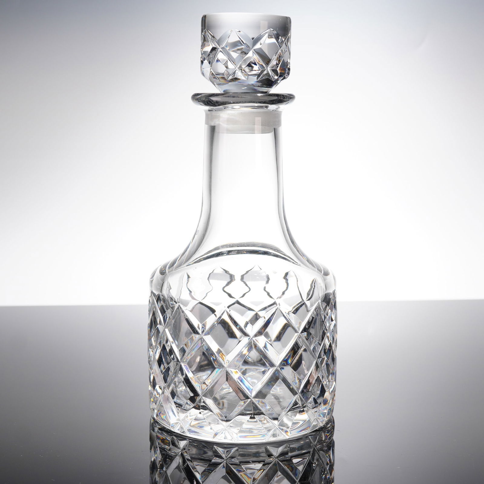 Orrefors Sofiero Crystal Decanter and Stopper: This is an Orrefors cut crystal decanter set in the Sofiero patern, consisting of the decanter botle and its matching stopper. The decanter features a squat, bulbous body heavily decorated with deep d