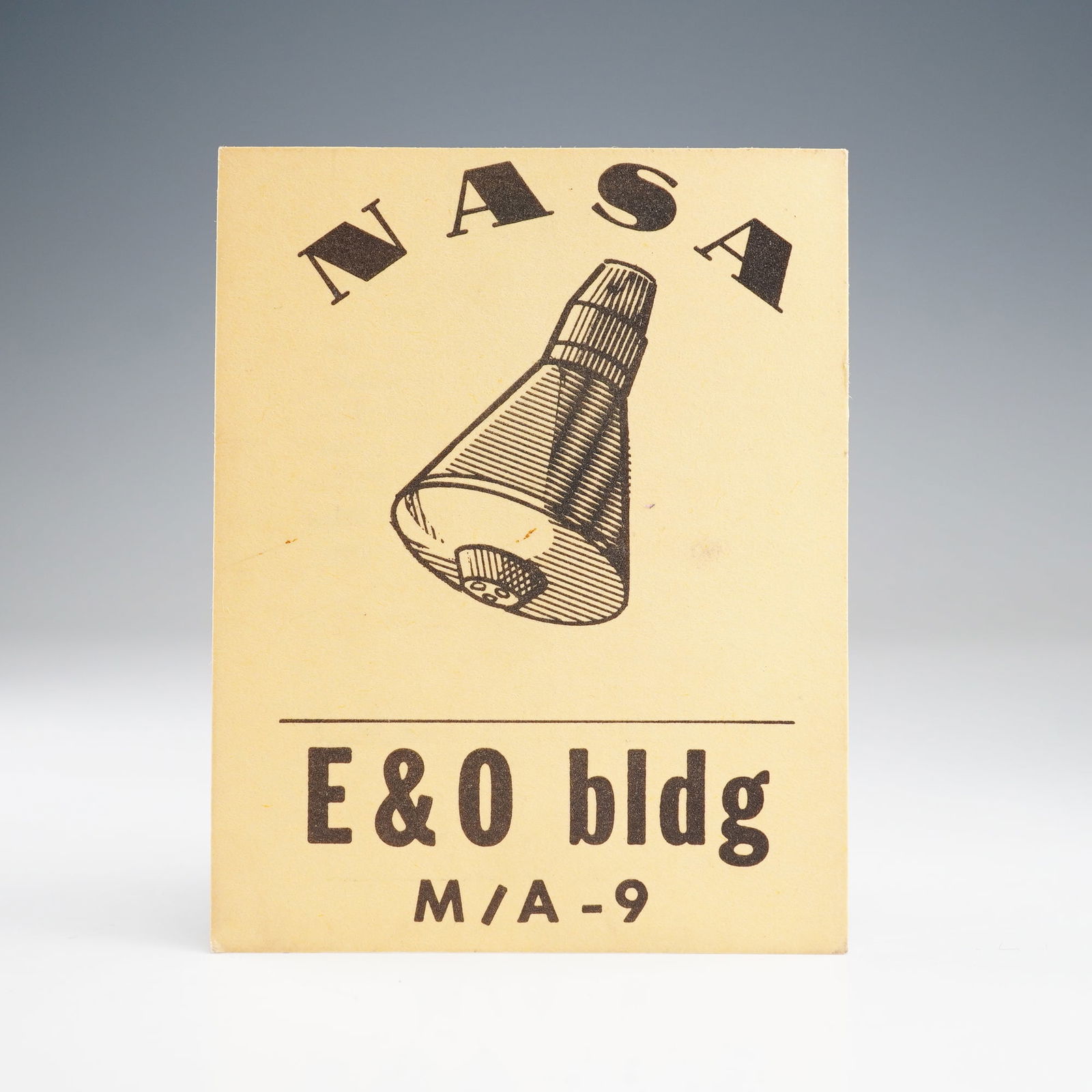 NASA M/A-9 Engineering and Operations Building Access Pass: A vintage NASA access pass for the early 1960s Mercury program, identifying E&O bldg M/A'9. Front shows NASA logo and Mercury capsule graphic. Reverse includes U.S. Government Property warning, Securi