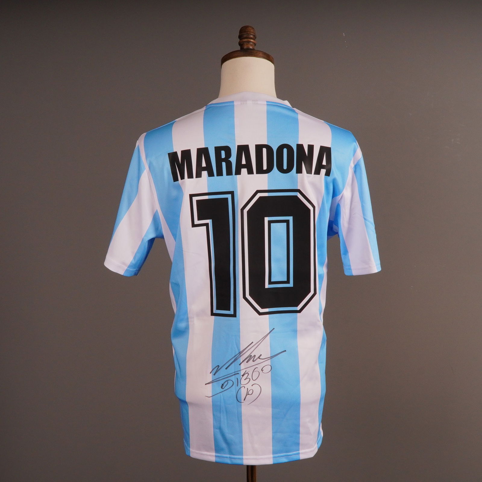 Diego Maradona Autographed 1986 Argentina Replica Soccer Jersey: A two-piece lot consisting of an autographed replica 1986 Argentina National team home soccer jersey and its corresponding Certificate of Authenticity (COA). The jersey is constructed of white and