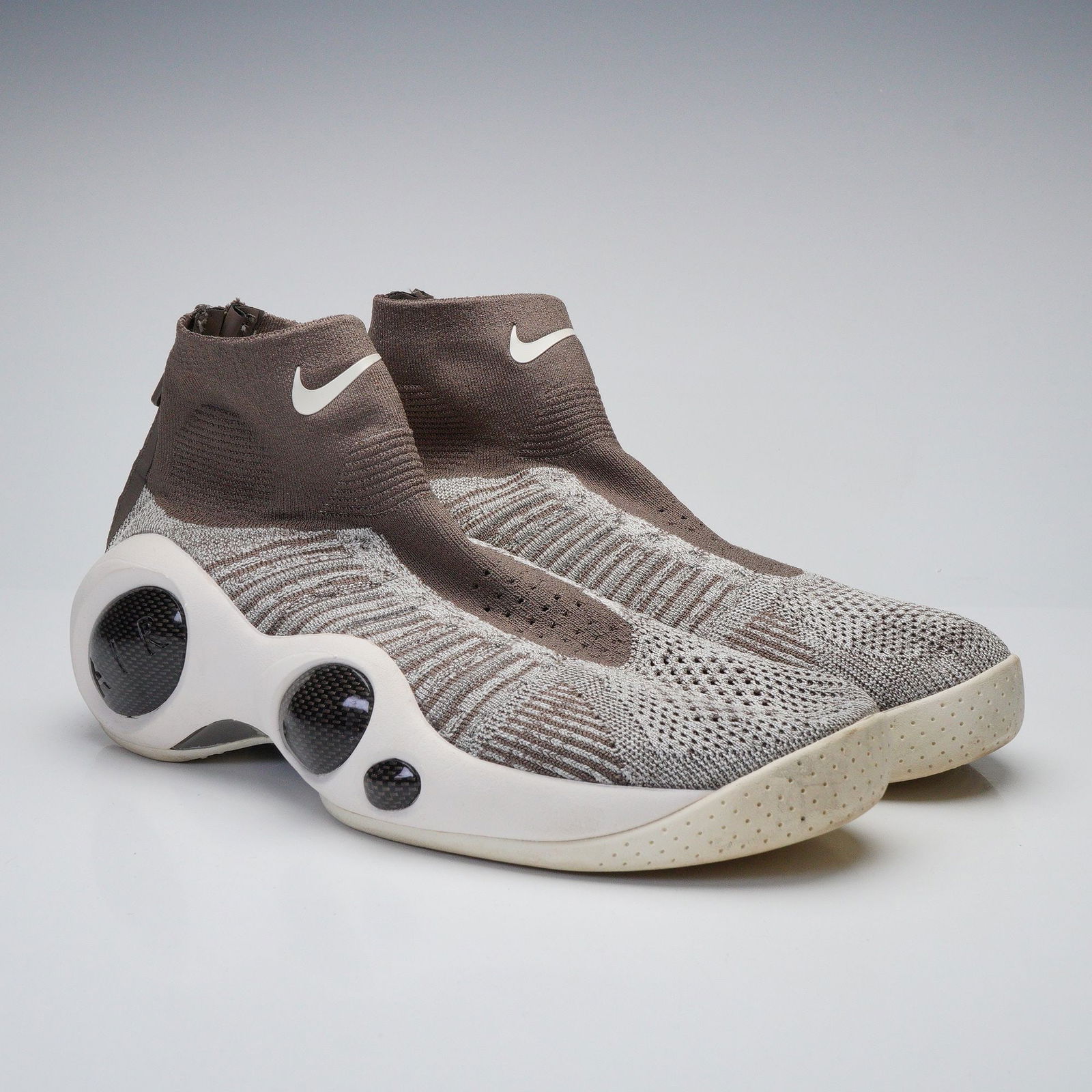A Pair of Nike Flight Bonafide Khaki Sneakers, Model 917742-201: A pair of Nike Flight Bonafide Khaki athletic sneakers, model 917742-201. These modern, high-top sneakers feature a futuristic design with a variegated grey and light brown knitted textile upper and