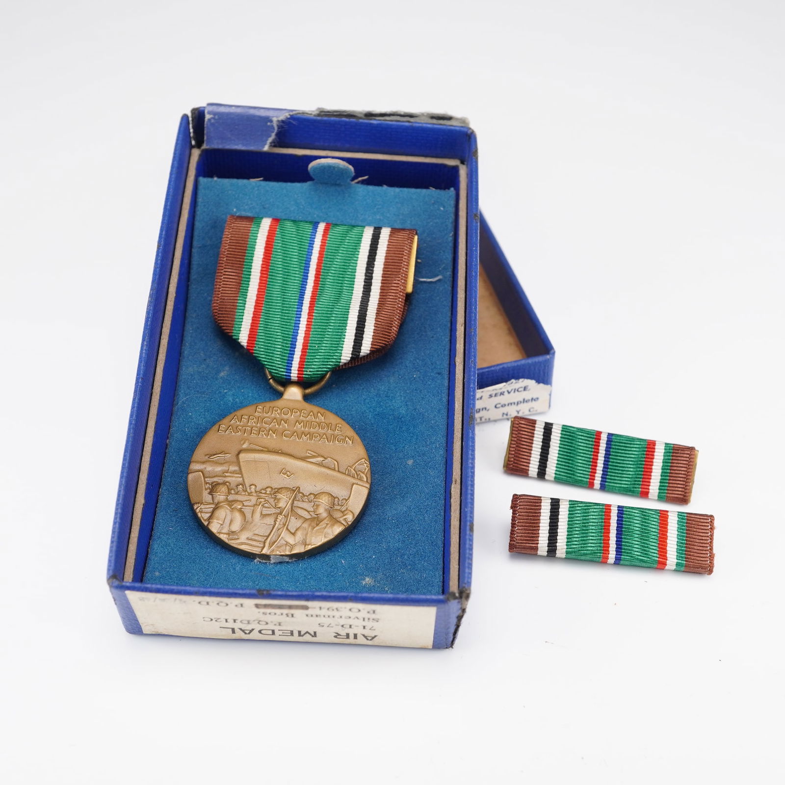 U.S. WWII European African Middle Eastern Campaign Medal: A United States World War II European African Middle Eastern Campaign Medal, complete with its original issue box and two accompanying ribbon bars. The bronze medal features a detailed relief of troop