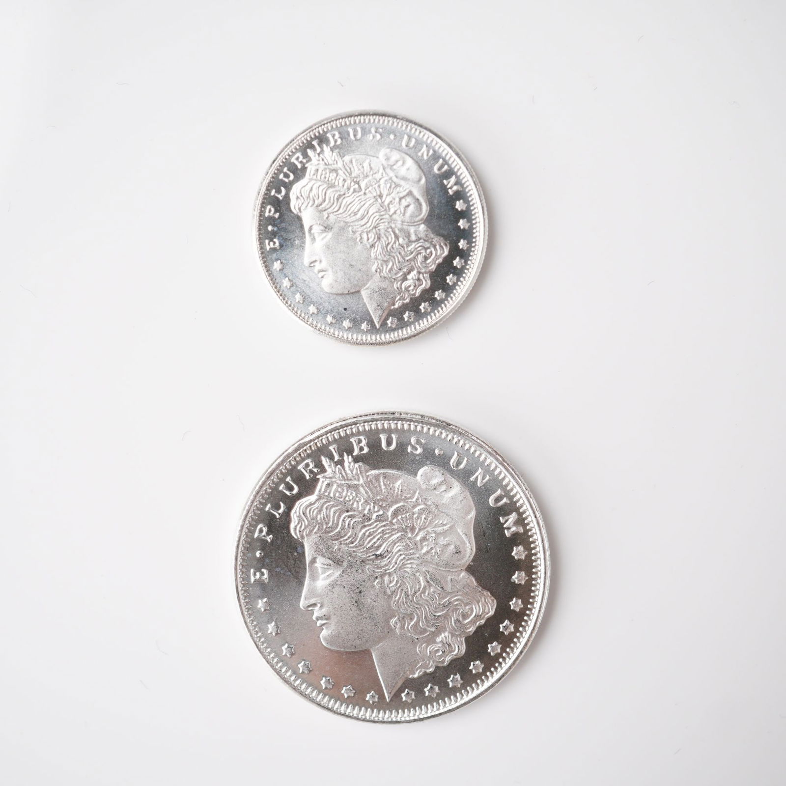 2pc 1/2 Troy Ounce and 1/4 Troy Ounce Morgan Silver Rounds: A two-piece lot of silver rounds, each struck in .999 fine silver and bearing the classic Morgan Dollar design. The obverses feature the left-facing portrait of Lady Liberty wearing a Phrygian cap