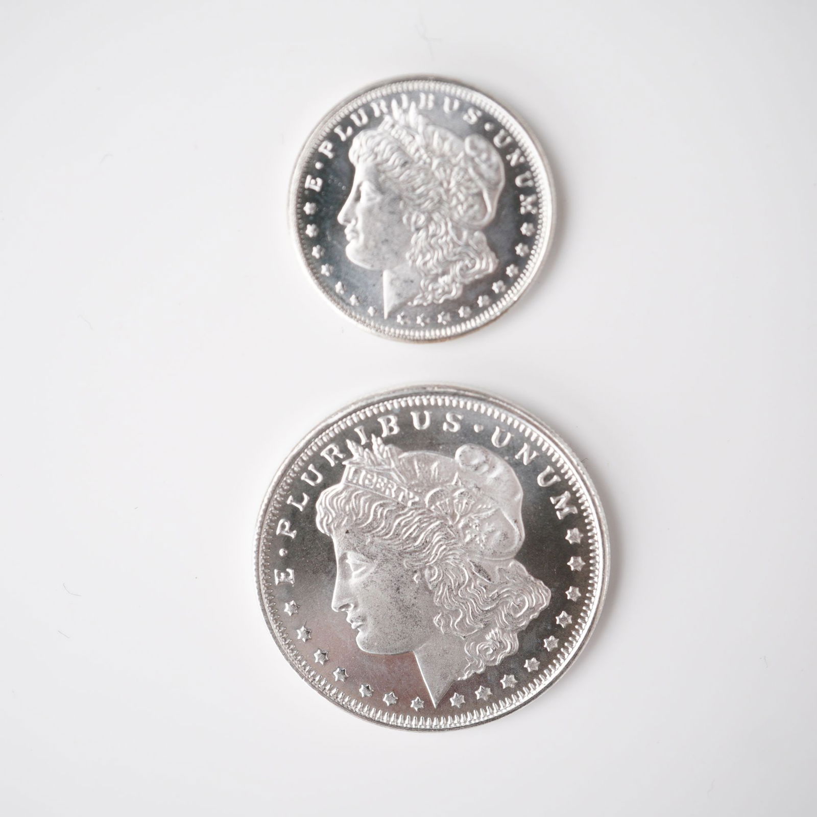 2pc Highland Mint Morgan Silver 1/2 and 1/4 Troy Ounce Coins: A 2-piece grouping of Highland Mint Morgan silver fractional coins, comprised of one 1/2 troy ounce and one 1/4 troy ounce specimen. Each coin is struck in .999 fine silver. These coins replicate the