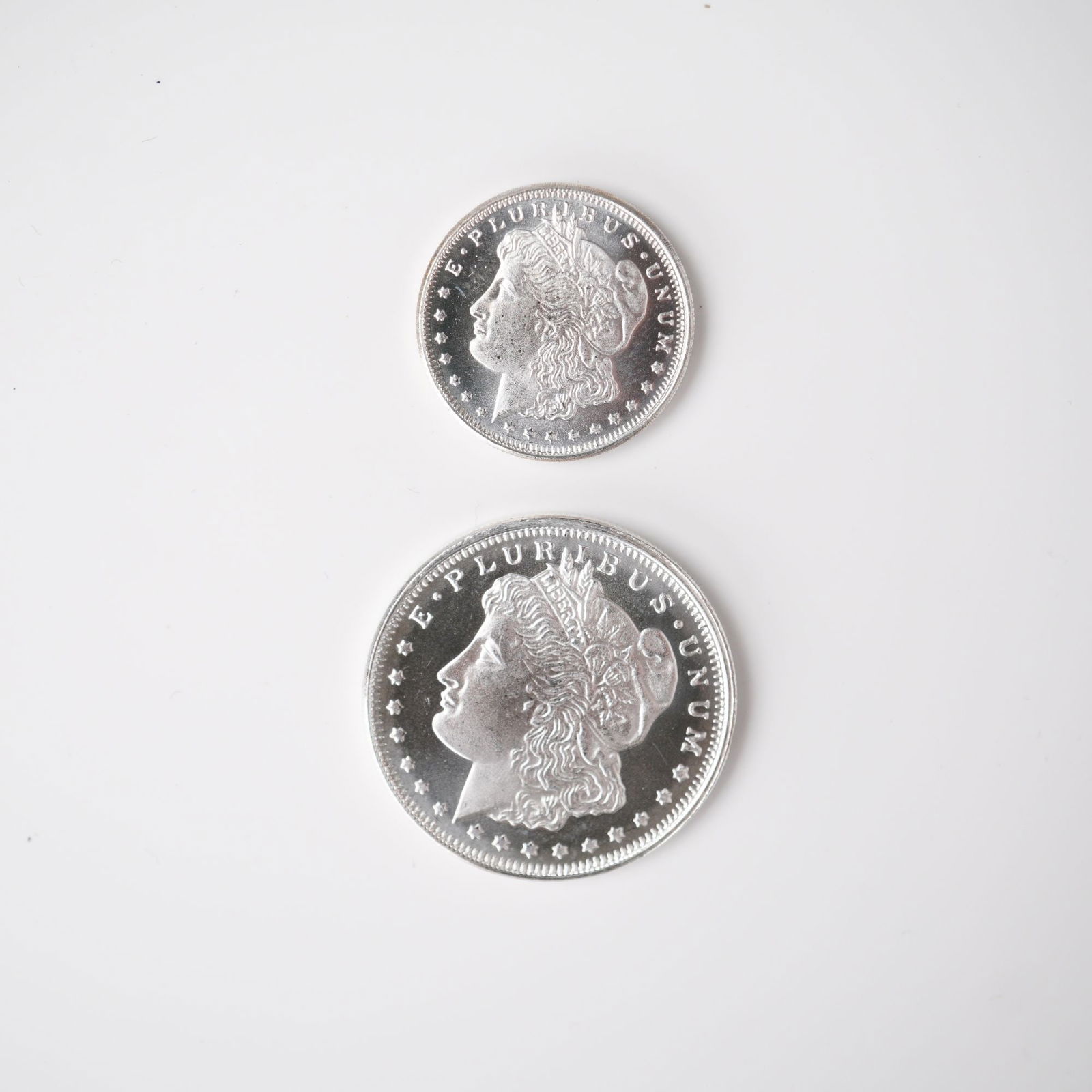 2pc Highland Mint Morgan Silver 1/2 and 1/4 Troy Ounce Coins: Two silver coins issued by the Highland Mint, each struck in .999 fine silver and modeled after the celebrated Morgan dollar design. Included are one half troy ounce coin and one quarter troy ounce