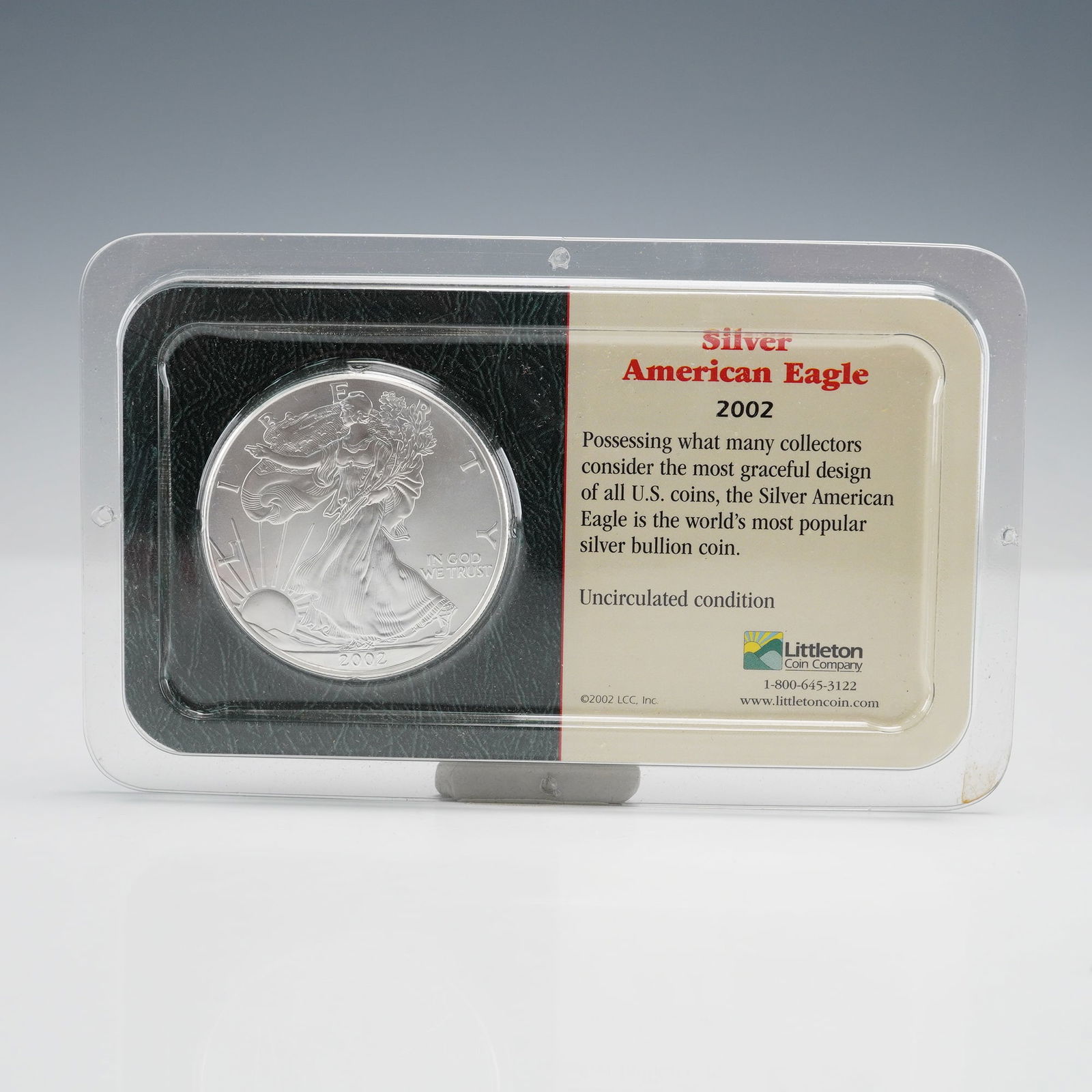 2002 American Silver Eagle in Littleton Silverpak Holder: A 2002 American Silver Eagle in a clear Silverpak holder. Obverse: Walking Liberty, LIBERTY, IN GOD WE TRUST, 2002. Reverse: Heraldic Eagle, UNITED STATES OF AMERICA, 1 OZ. FINE SILVER - ONE DOLLAR.