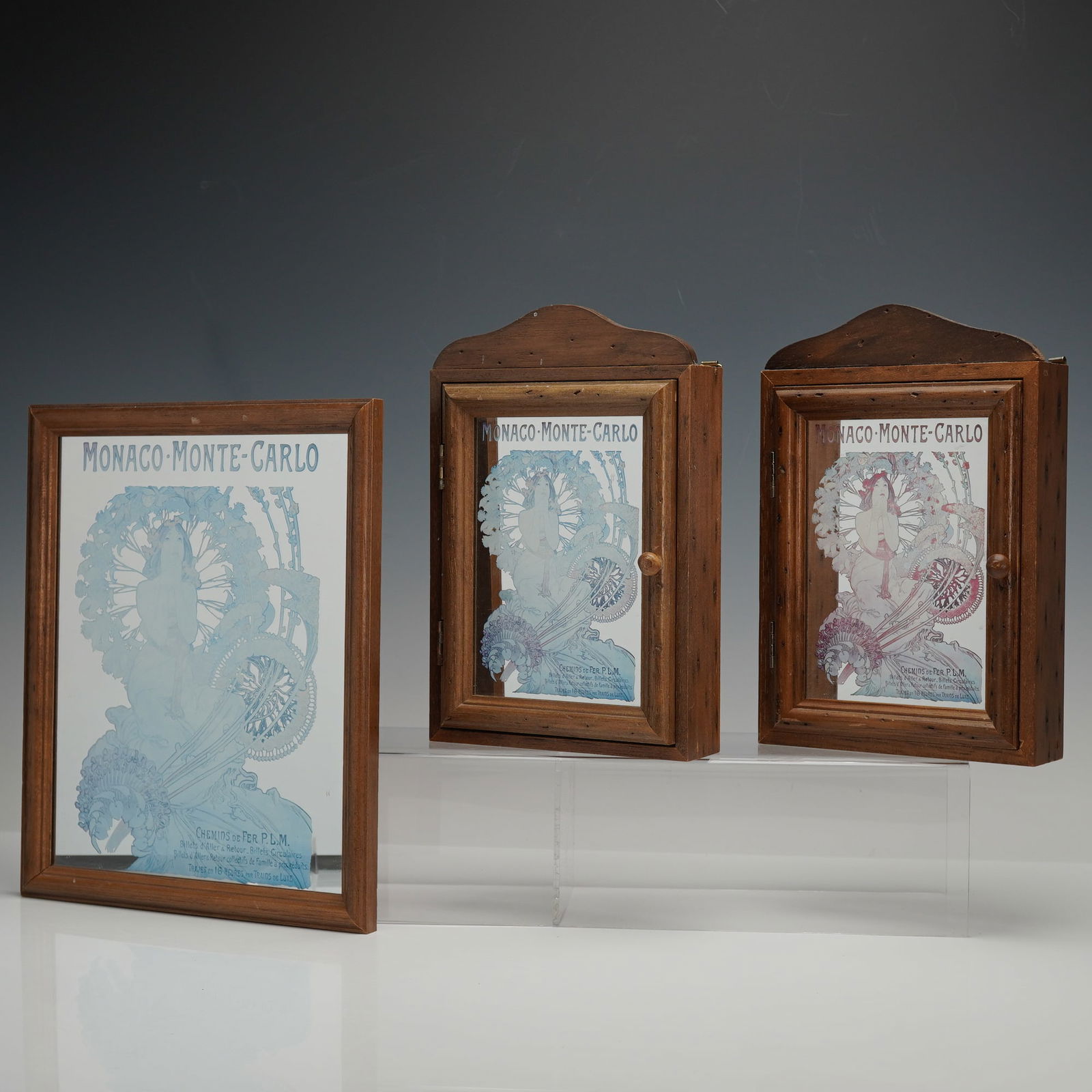 3pc After Alphonse Mucha Wall Cabinets & Wall Mirror, Monaco-Monte-Carlo: A group of two wall-mounted key cabinets and one wall mirror, each incorporating a mirror image of Alphonse Mucha's 1897 Art Nouveau poster "Monaco-Monte-Carlo," originally produced for the P.L.M. rai