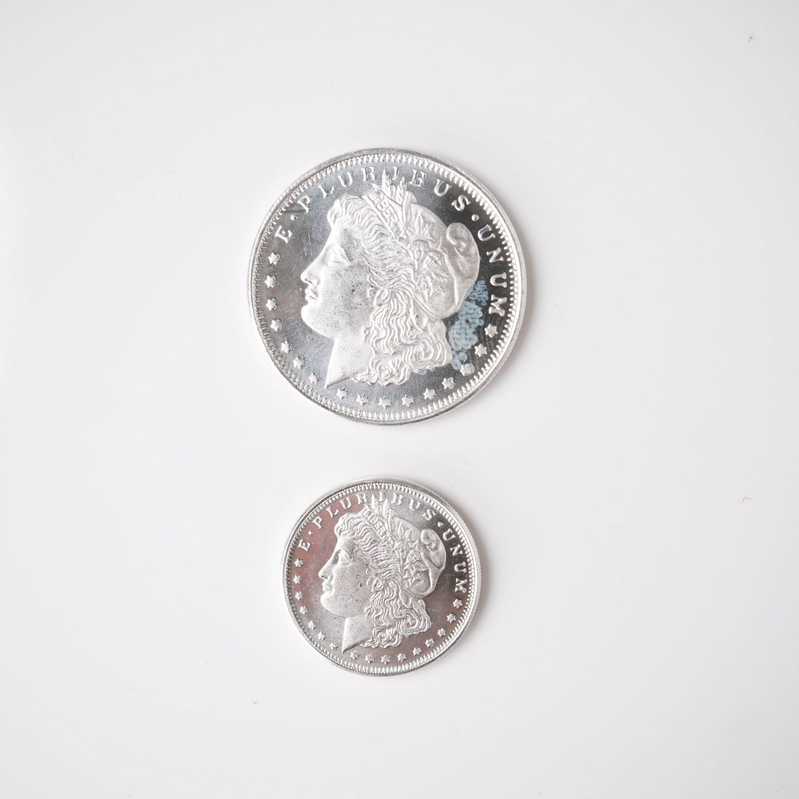 2pc 1/2 Troy Ounce and 1/4 Troy Ounce Morgan Silver Rounds: A two-piece lot of silver rounds, each struck in .999 fine silver and modeled after the historic Morgan Dollar design. The obverses feature the left-facing portrait of Lady Liberty, crowned with a