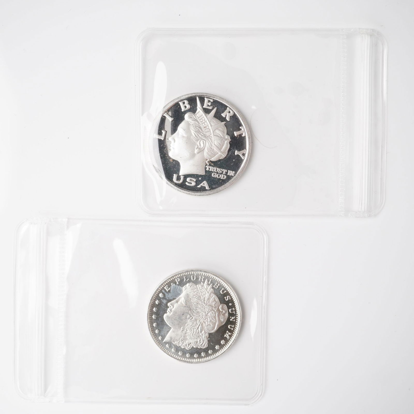 2pc 2003 1/2 Troy Ounce Five Dollar and Morgan Dollar Silver Rounds: A two-piece collection of silver rounds, each composed of .999 fine silver. The first is a 2003 Liberty Dollar, denominated at five dollars, displaying the radiant head of Liberty on the obverse with