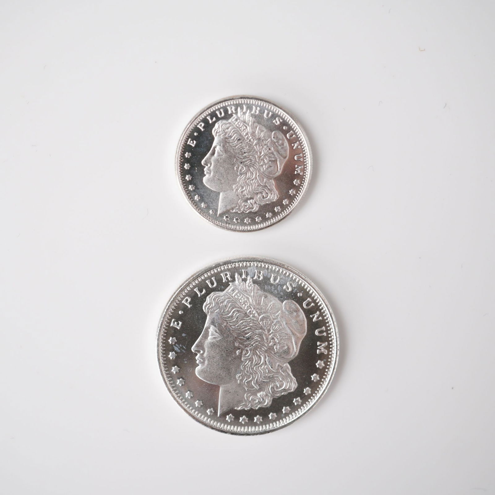 2pc Highland Mint Morgan Silver 1/2 and 1/4 Troy Ounce Coins: A matched two-piece set of Highland Mint Morgan Silver fractional bullion coins. Includes a one-quarter troy ounce .999 fine silver coin and a one-half troy ounce .999 fine silver coin. Both coins