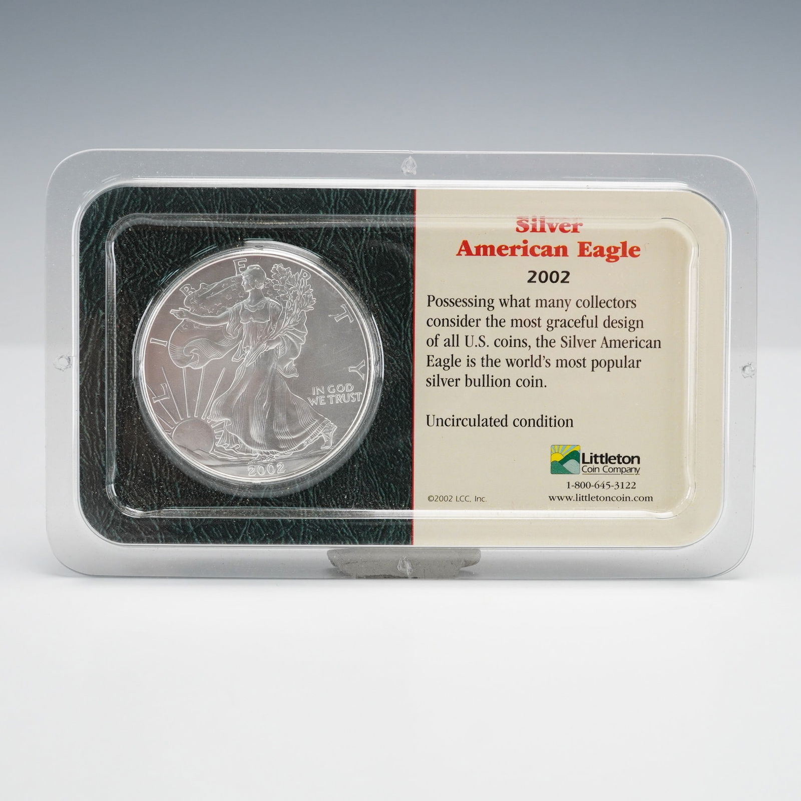 2002 American Silver Eagle 1 oz Uncirculated, Littleton: A 2002 American Silver Eagle One Ounce Uncirculated Coin in original Littleton packaging. Obverse: Lady Liberty, 2002, IN GOD WE TRUST. Reverse: Heraldic Eagle, UNITED STATES OF AMERICA, 1 OZ. FINE
