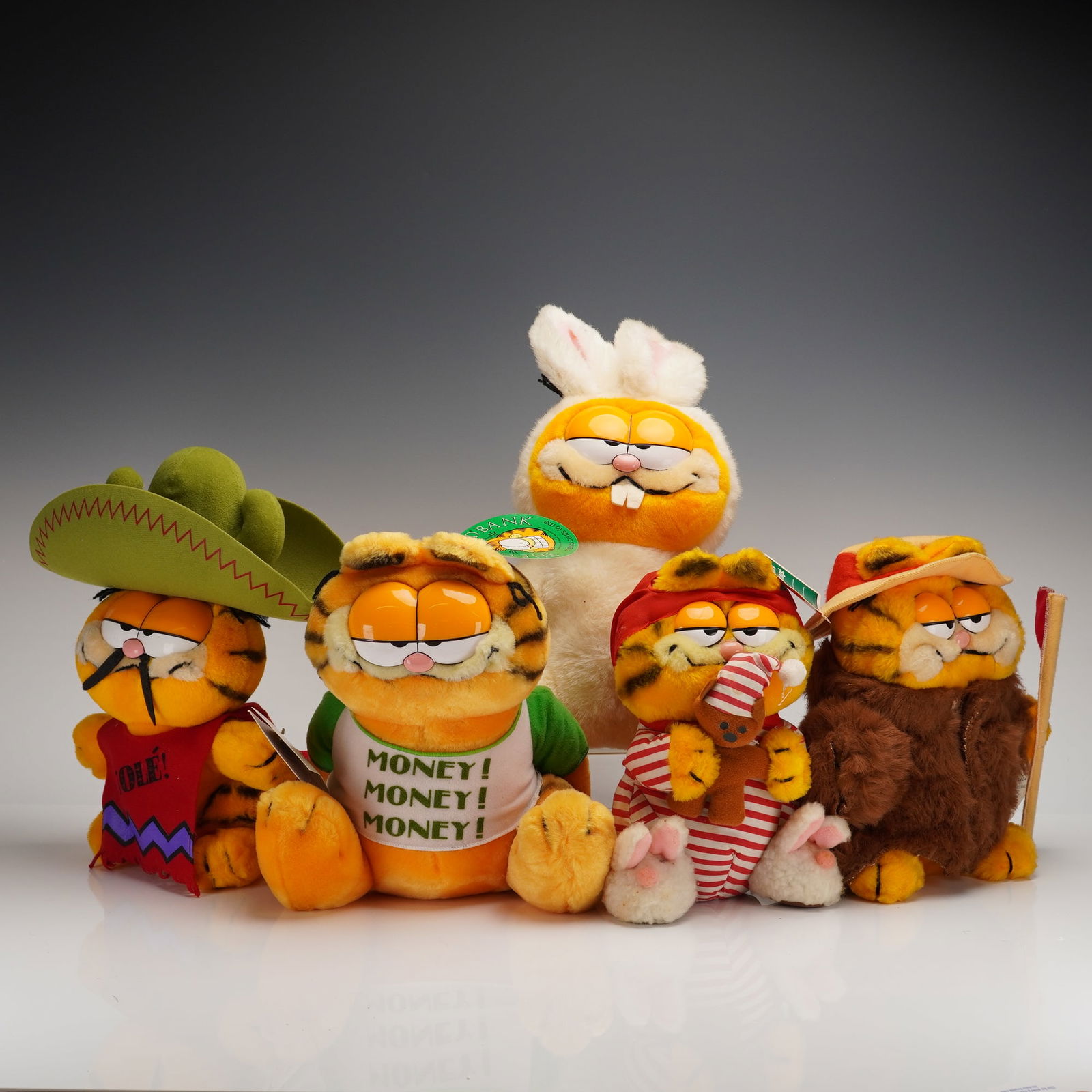 5 Vintage Garfield Plush Toys w/ Original Tags: A collection of five vintage licensed plush toys depicting the comic strip character Garfield. The figures are constructed primarily from synthetic plush fabric and feature various costumes. The colle