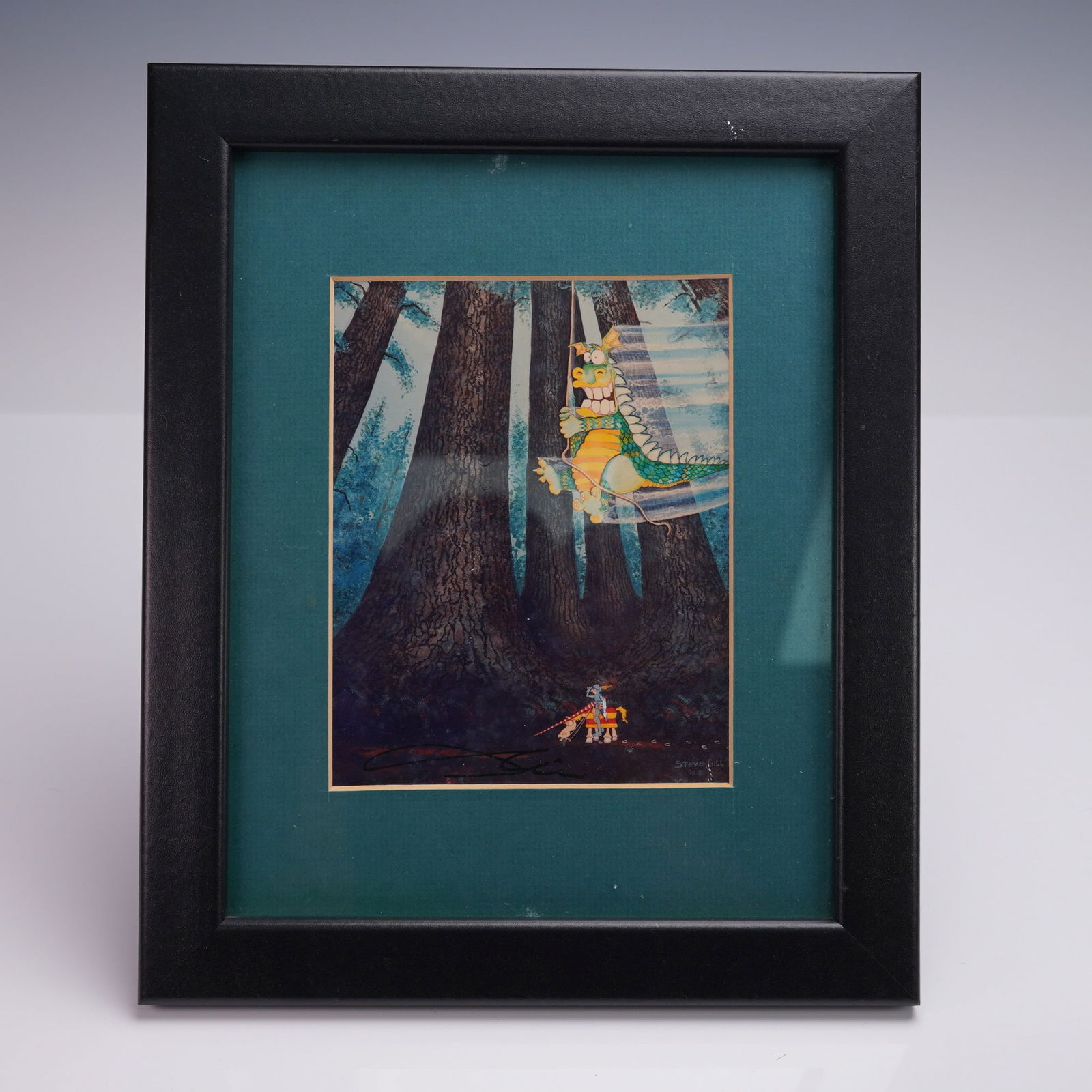 Framed Steve Gill Signed Fantasy Dragon Print 1990: Colorful fantasy art print by Steve Gill dated 1990, featuring a playful dragon swinging through a forest above a waiting knight. Artist signature appears in the lower left and printed name and date i