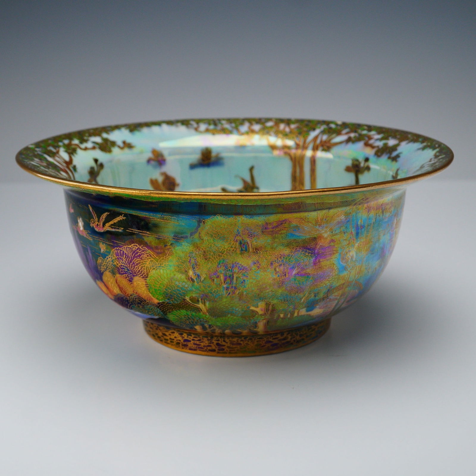 Wedgwood Fairyland Lustre K'ang Hsi Bowl, Woodland Elves Z4968: A Wedgwood Fairyland Lustre bowl decorated with both day and night scenes. The exterior is executed in the Black Fairyland 'Woodland Elves V - Woodland Bridge' pattern, depicting bridges, elves, and s