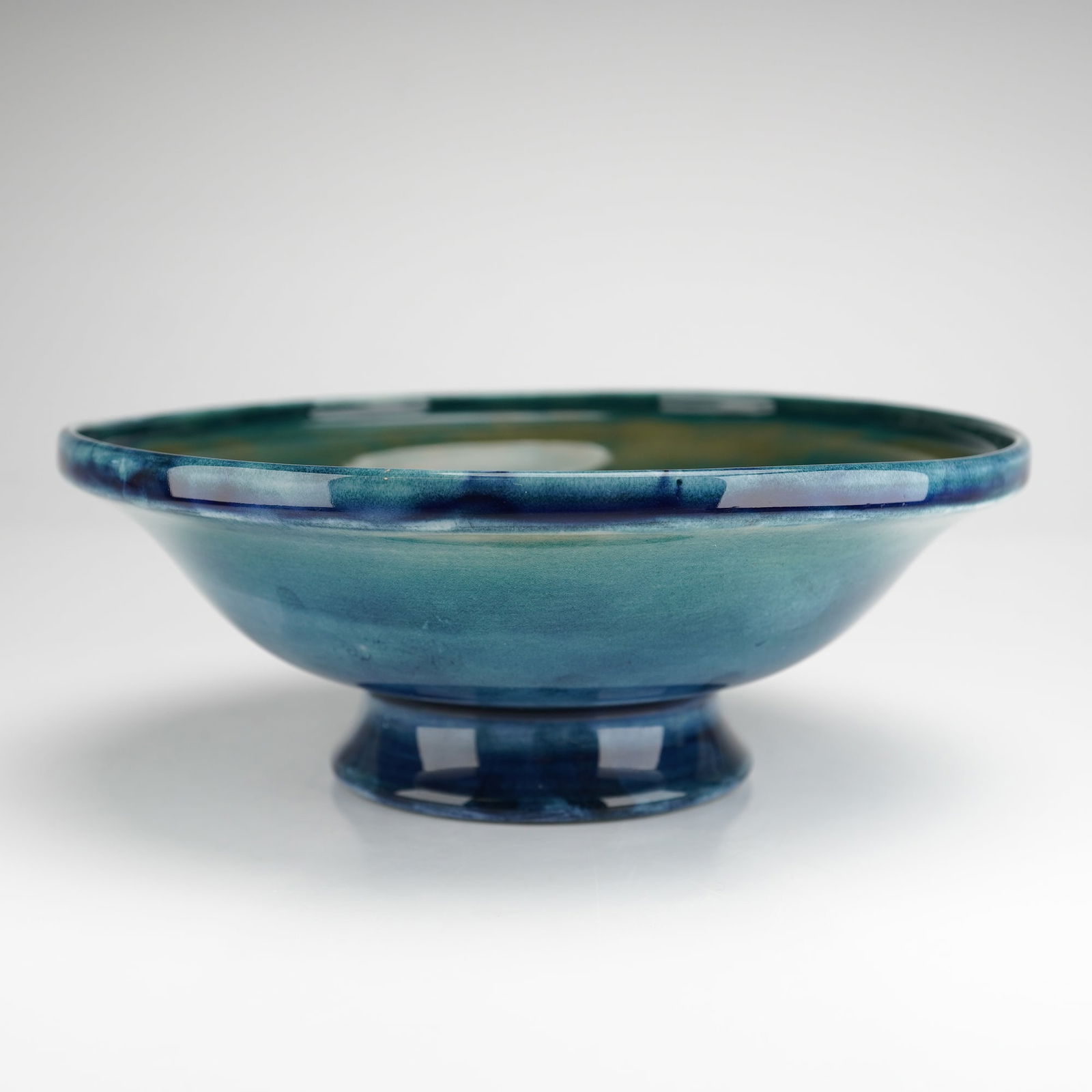 William Moorcroft footed dish, decorated in early Carp pattern: A William Moorcroft footed dish decorated in the early Carp pattern, featuring four swimming fish executed in finely tubelined detail. The interior displays rich aquatic tones of blue and green, with